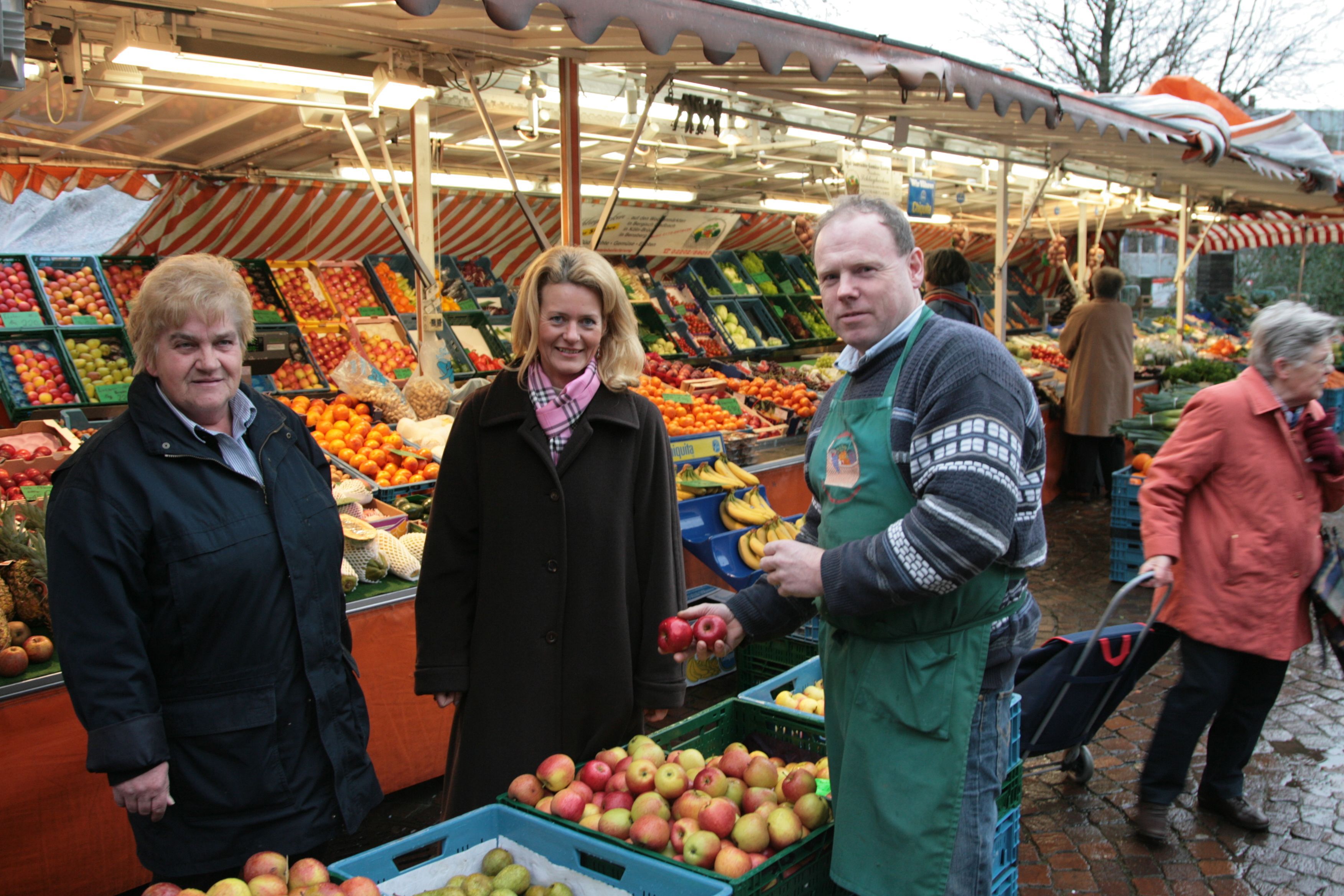 Ute Döpper (heute: Unrau) steht mit Marktbeschickern und Ordnungsamtsmitarbeiterin auf dem Gladbacher Wochenmarkt.