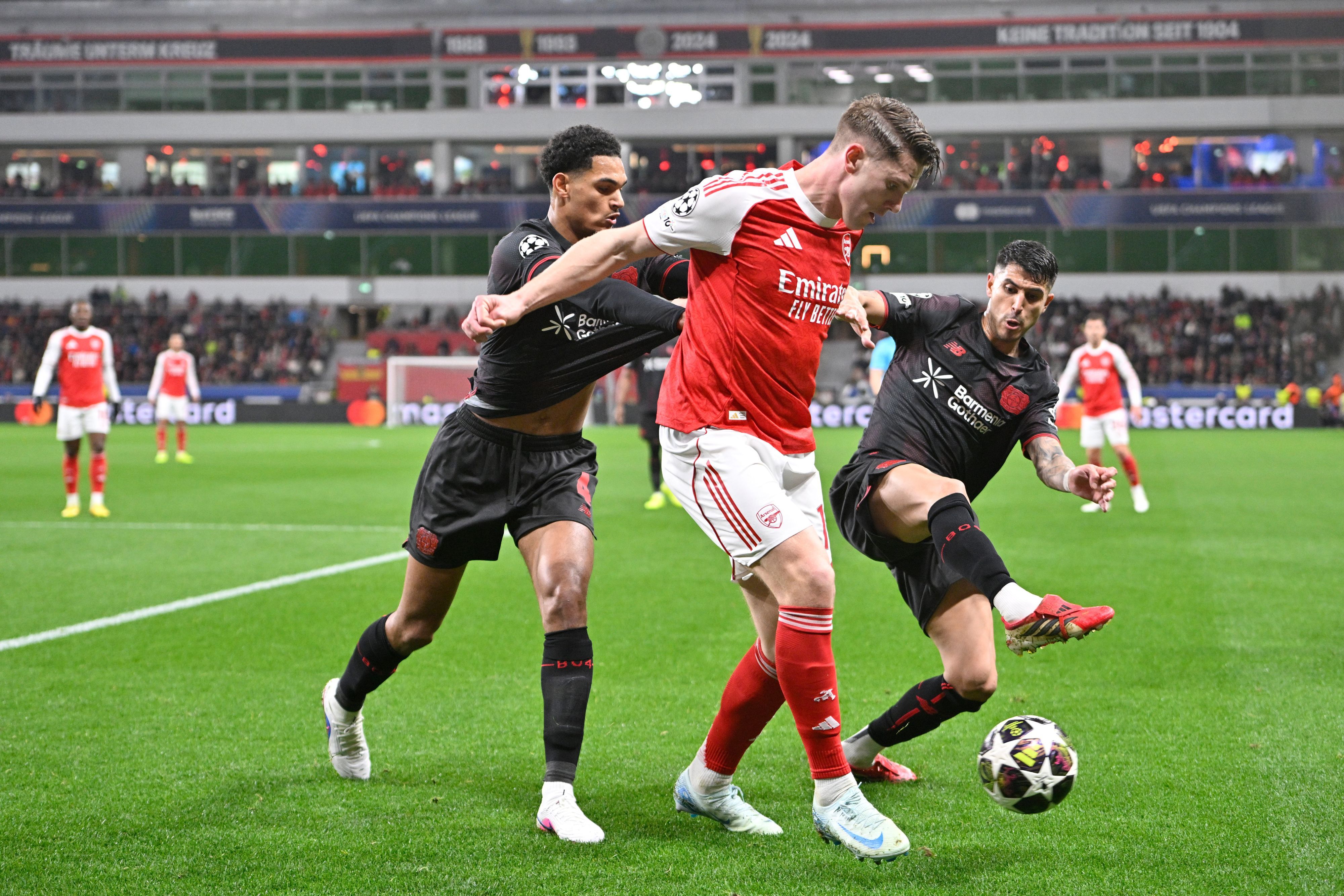 Fußball, Männer: Champions League, Bayer Leverkusen - FC Arsenal, K.o.-Runde, Achtelfinale, Hinspiele, BayArena, Jarell Quansah (Bayer Leverkusen), Viktor Gyökeres (FC Arsenal) und Exequiel Palacios (Bayer Leverkusen) (l-r) kämpfen um den Ball. +++ dpa-Bildfunk +++
