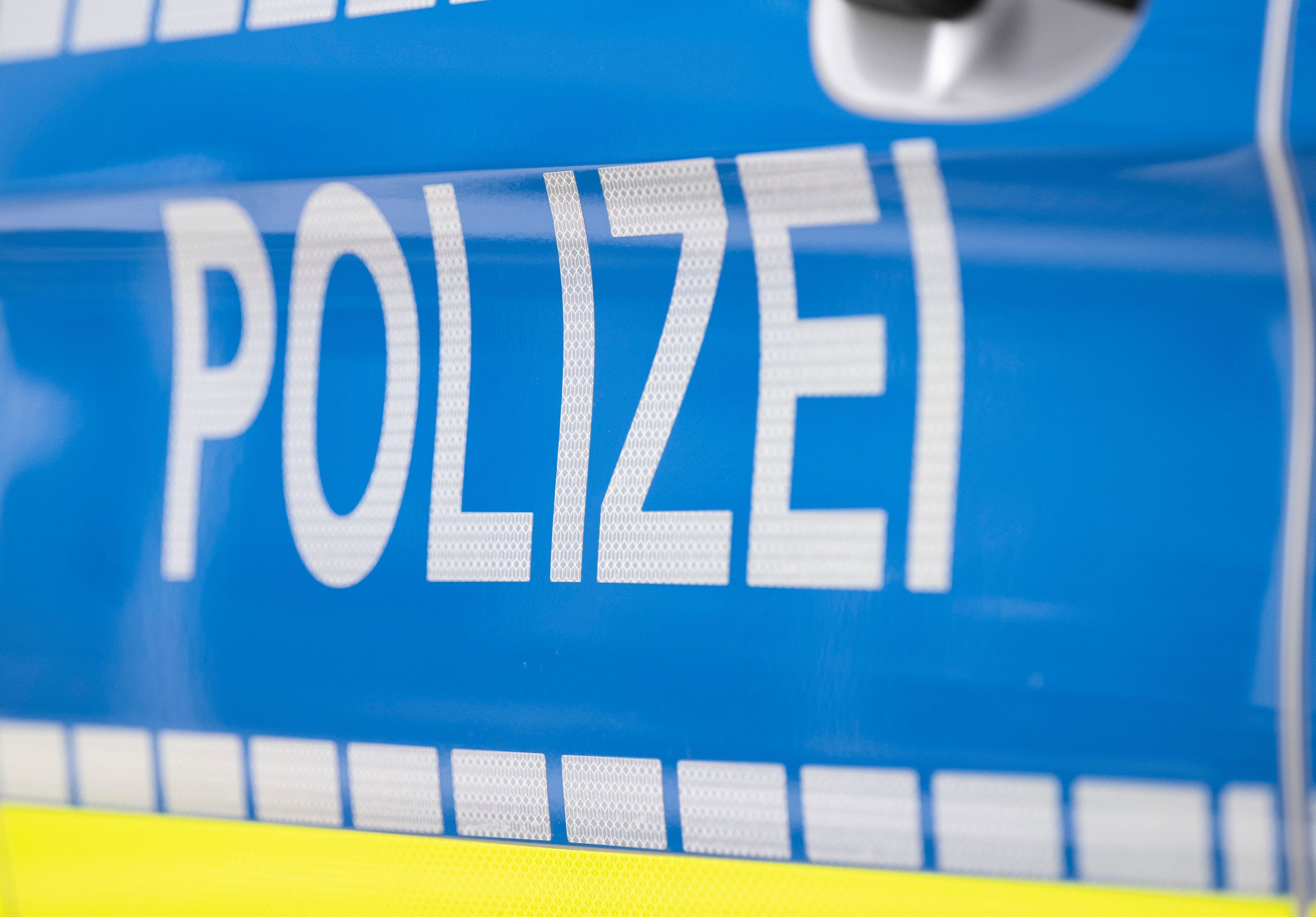 Der Schriftzug „Polizei“ ist auf einem Streifenwagen zu lesen.