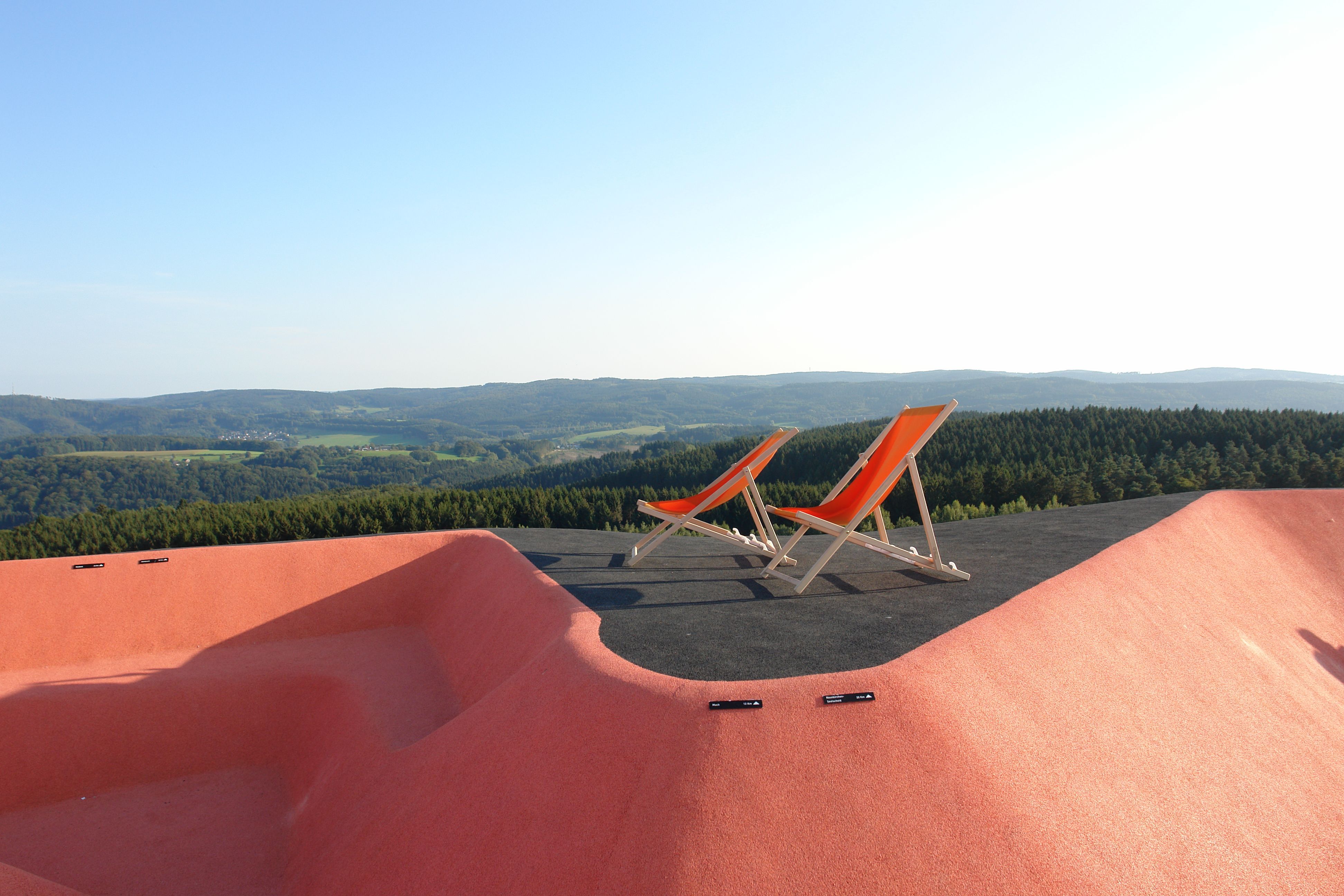 Zwei Liegenstühle vor Panorama.