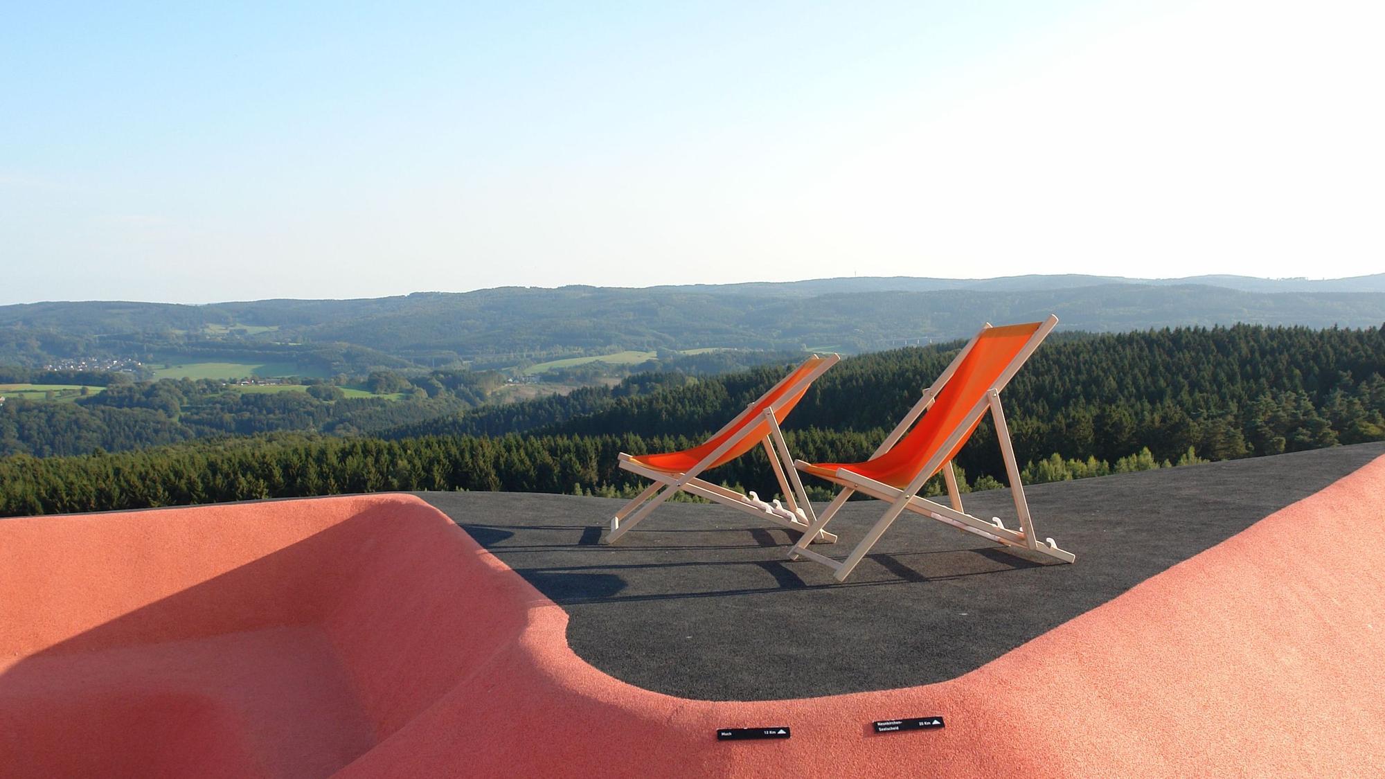 Zwei Liegenstühle vor Panorama.