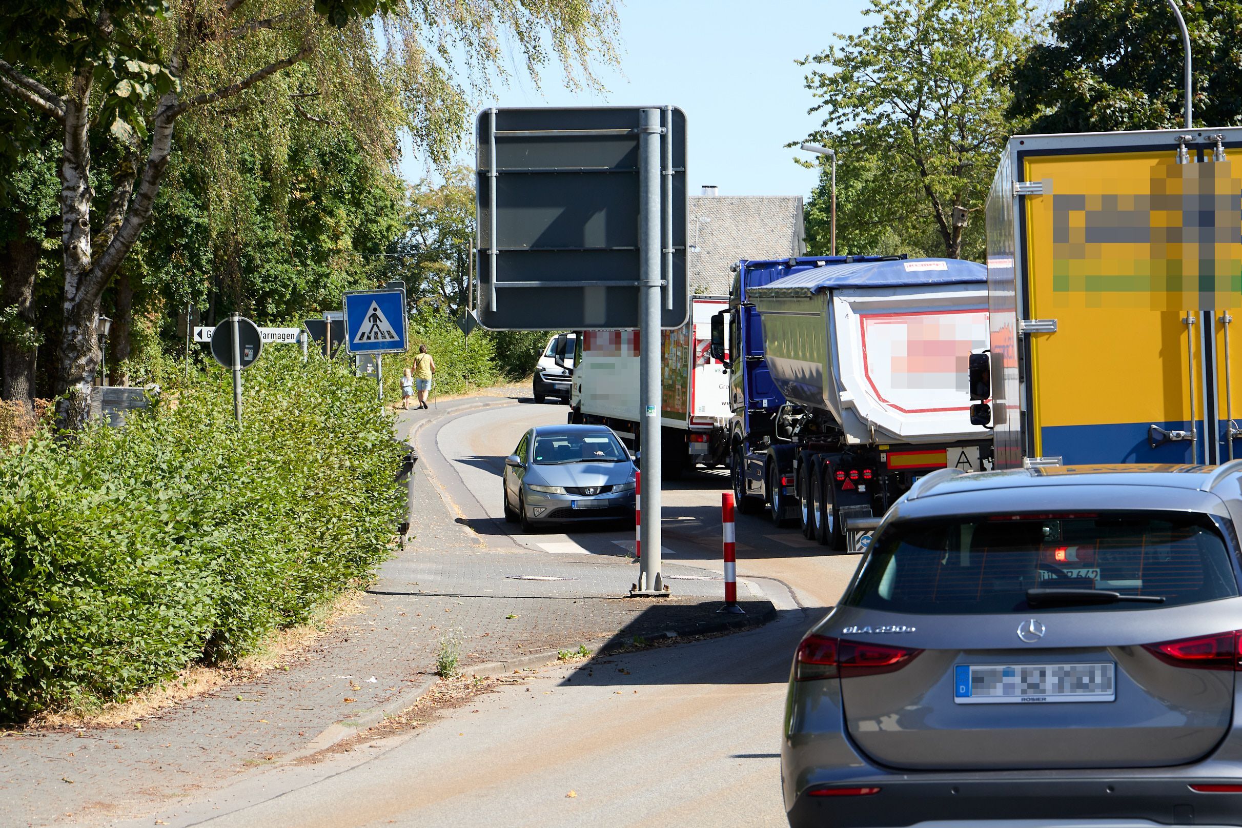 Zahlreiche Lastwagen und Autos versuchen, die Engstelle an der Grundschule in Marmagen zu passieren.