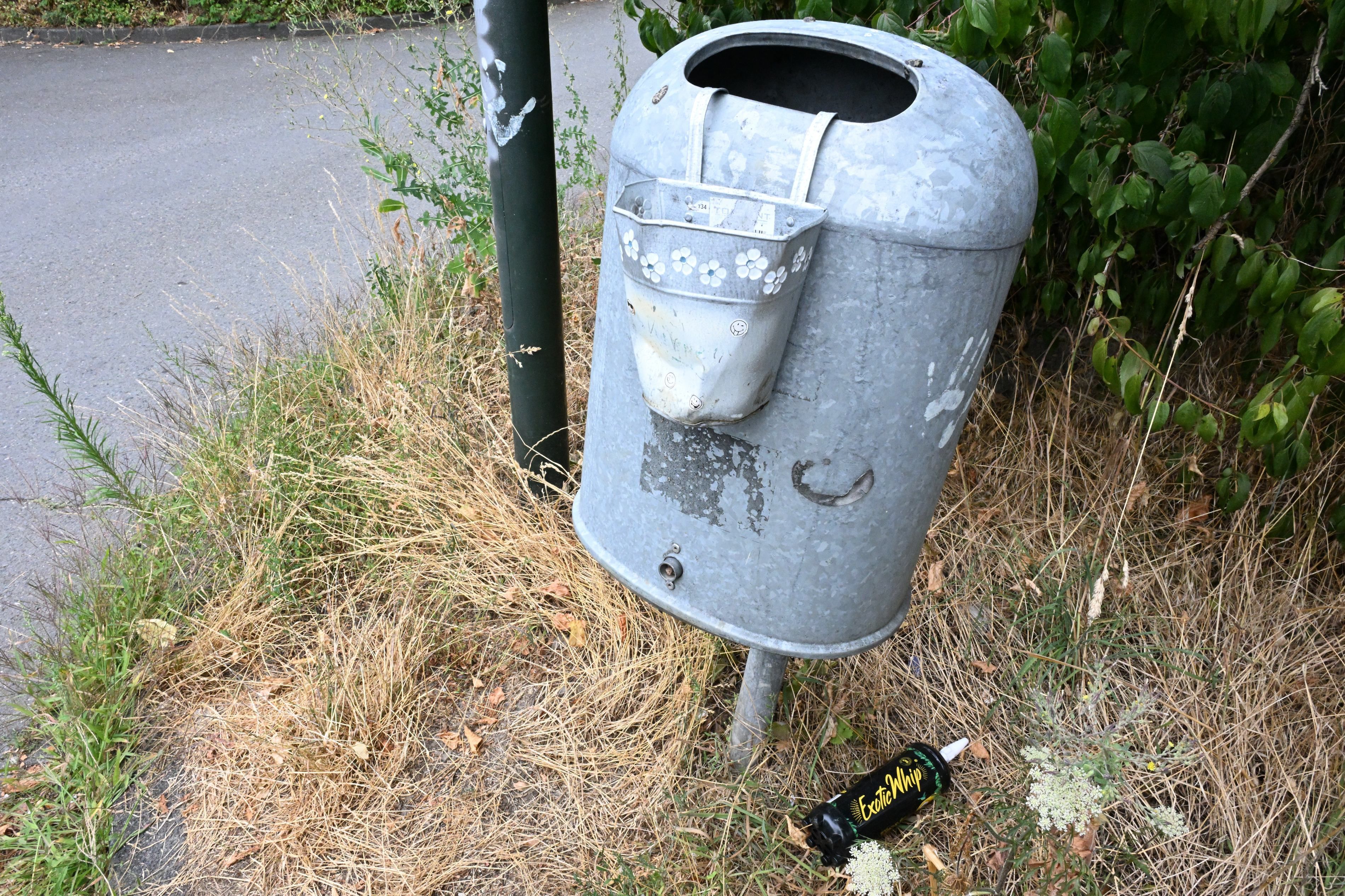 Zu sehen ist ein Mülleimer mit einem kleinen Blecheimer daran, in dem Kippenstummel entsorgt werden können.