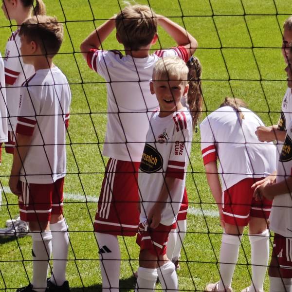 Elijah steht lächeln auf dem Platz neben den anderen Einlaufkindern.