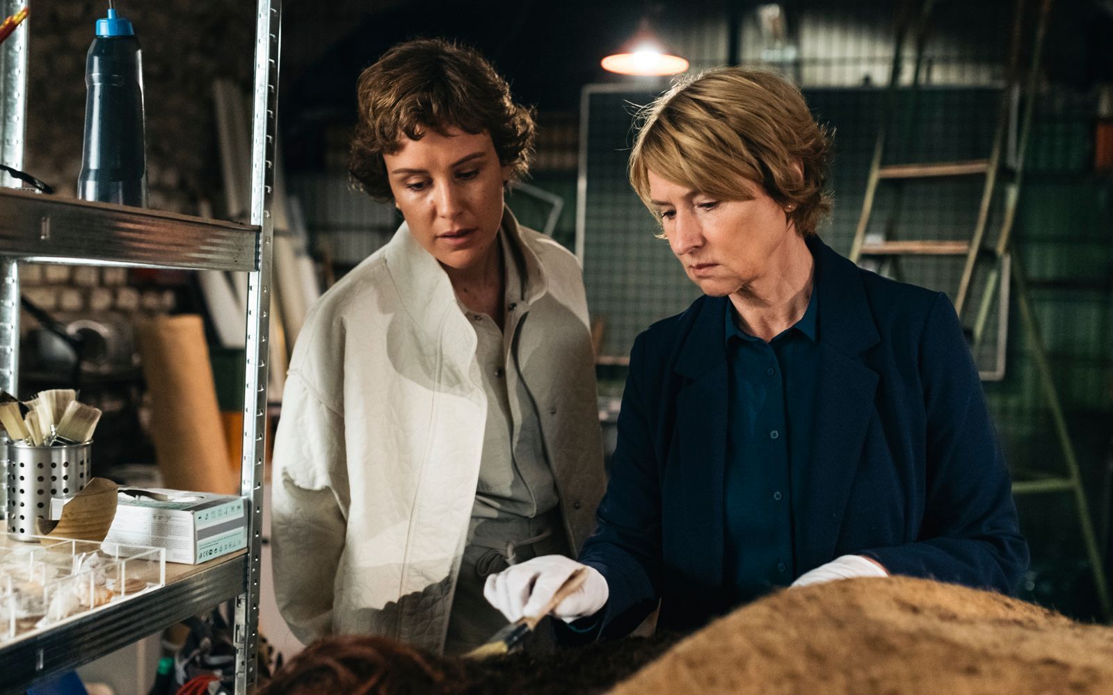 Die Professorin Ursula Scheuner (Corinna Harfouch) begutachtet mit ihrer neuen Assistentin Melanie (Carla Juri) eine illegal geborgene Moorleiche. (Bild: Coin FIlm/Silviu Guiman/X Verleih)