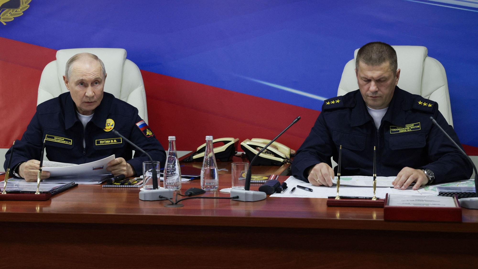 Auf diesem von der russischen Staatsagentur Sputnik verbreiteten Pool-Foto nehmen der russische Präsident Wladimir Putin und der Kommandeur der russischen Pazifikflotte, Admiral Viktor Liina, am 12. August 2026 während der Abschlussphase eines Manövers der Pazifikflotte auf der russischen Insel Sachalin an Bord des Lenkwaffenkreuzers „Warjag“ an einer Besprechung teil.