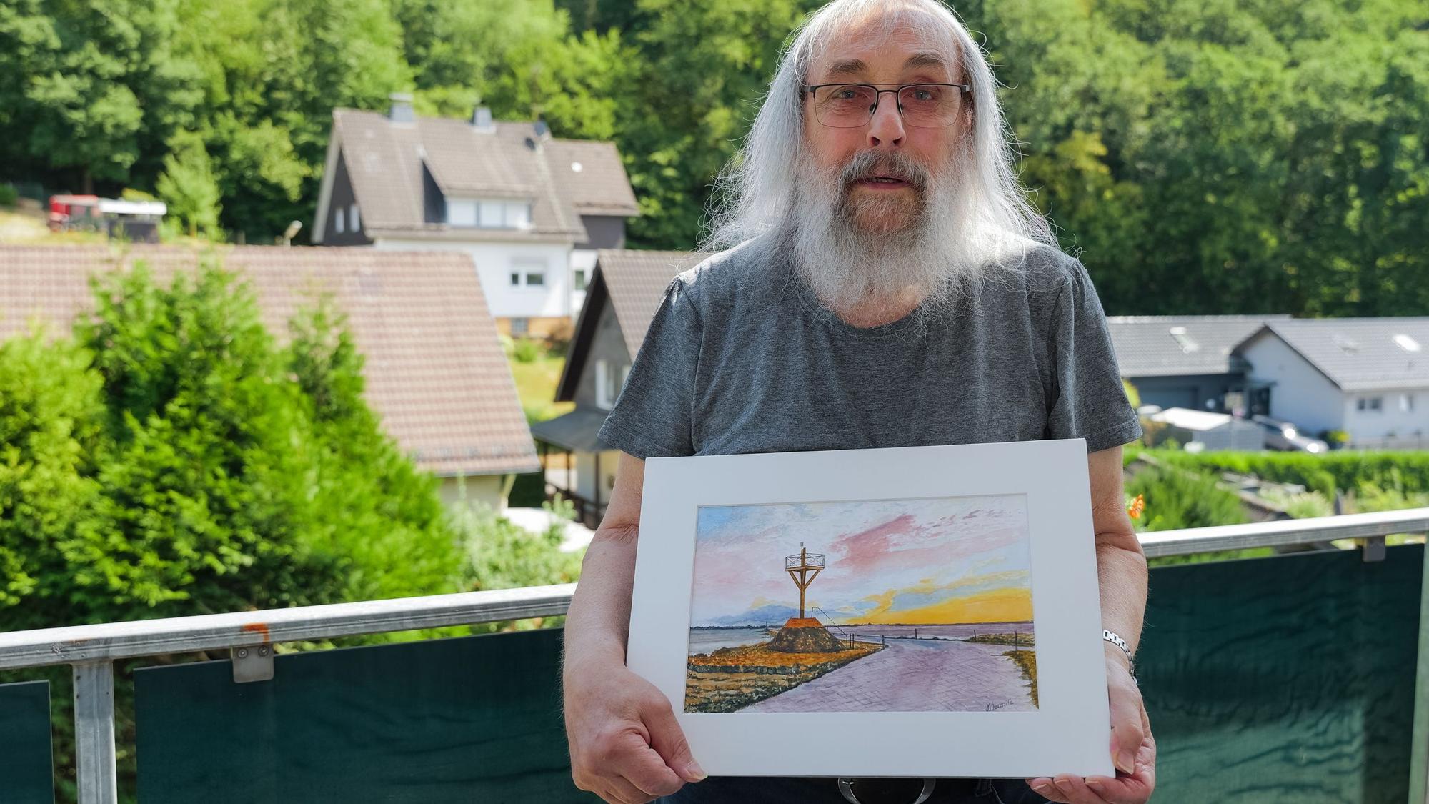 Georg Seifert aus Engelskirchen-Schnellenbach zeigt das Bild von Jean Marie Hermite aus La Roche-sur-Yon, auf dem die Passage du Gois zu sehen ist.