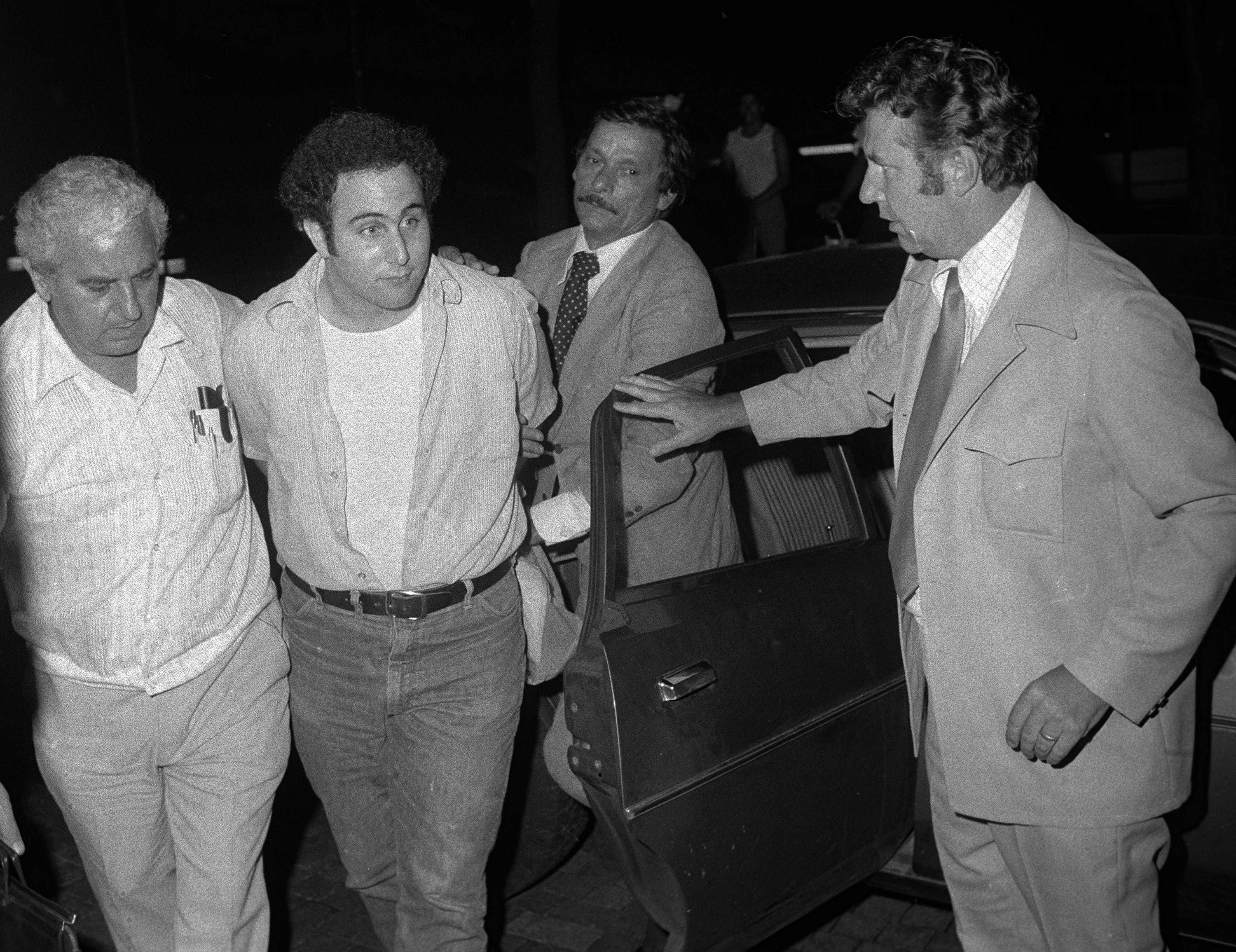 Der unter Mordverdacht stehende David Berkowitz wird 1977 mit Handschellen von Polizisten zum Polizeipräsidium in Lower Manhattan gebracht.