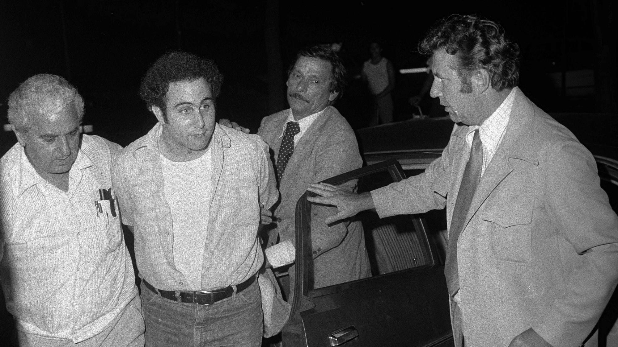 Der unter Mordverdacht stehende David Berkowitz wird 1977 mit Handschellen von Polizisten zum Polizeipräsidium in Lower Manhattan gebracht.