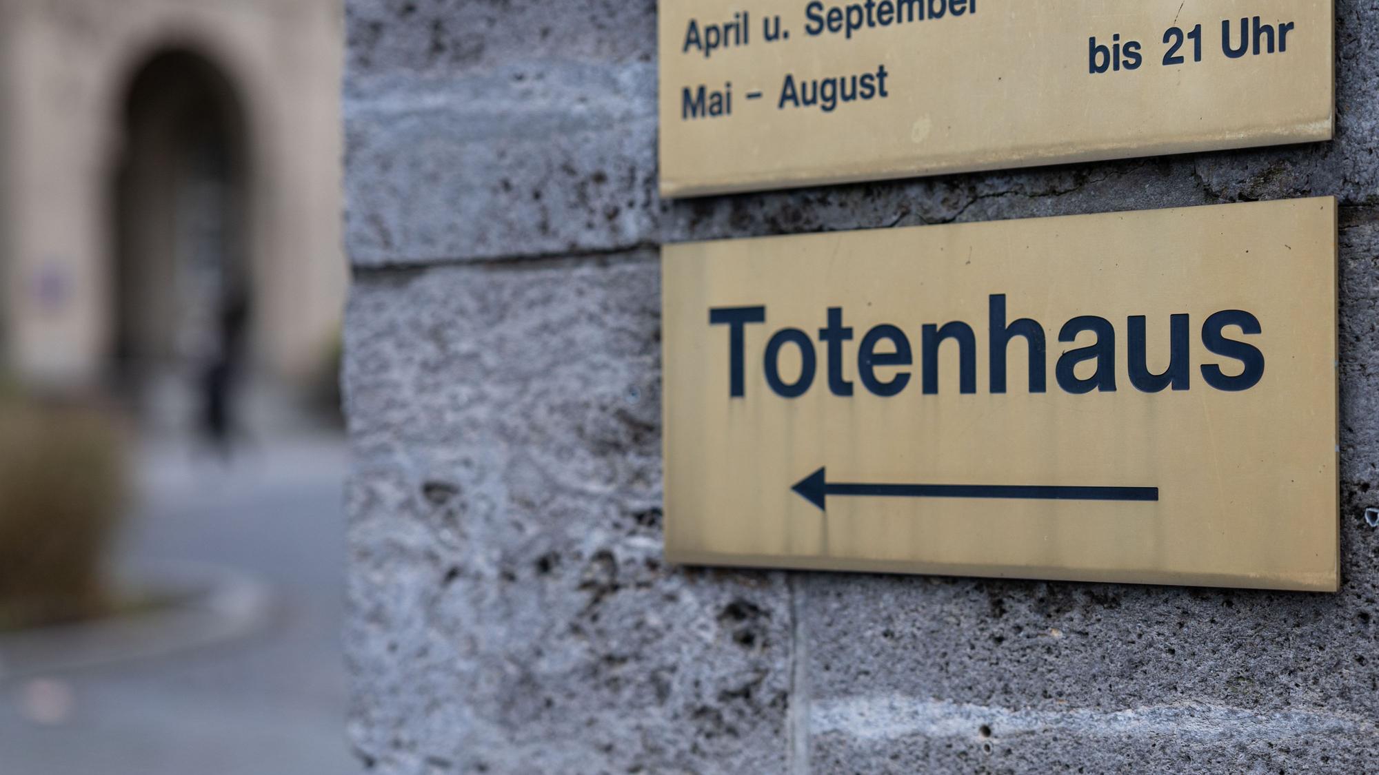 An einer Mauer des Hauptfriedhof in Frankfurt am Main hängt ein Schild «Totenhaus».