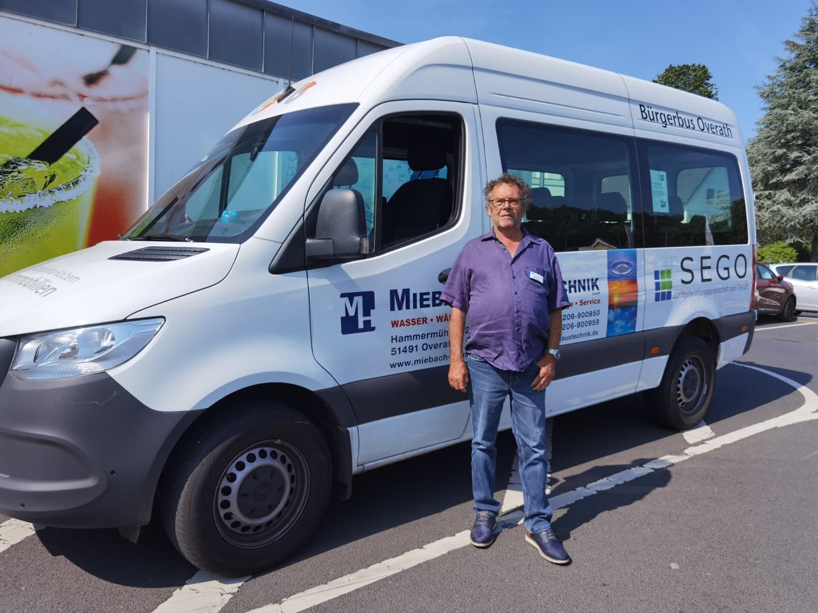 Zu sehen ist ein Bürgerbus und im Vordergrund ein Mann.