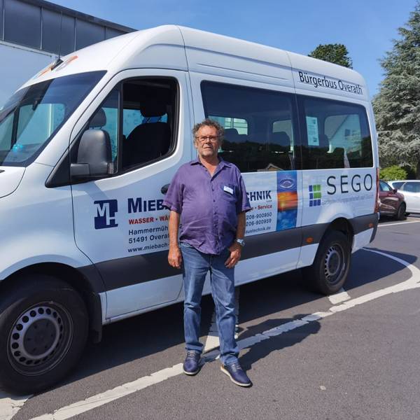 Zu sehen ist ein Bürgerbus und im Vordergrund ein Mann.
