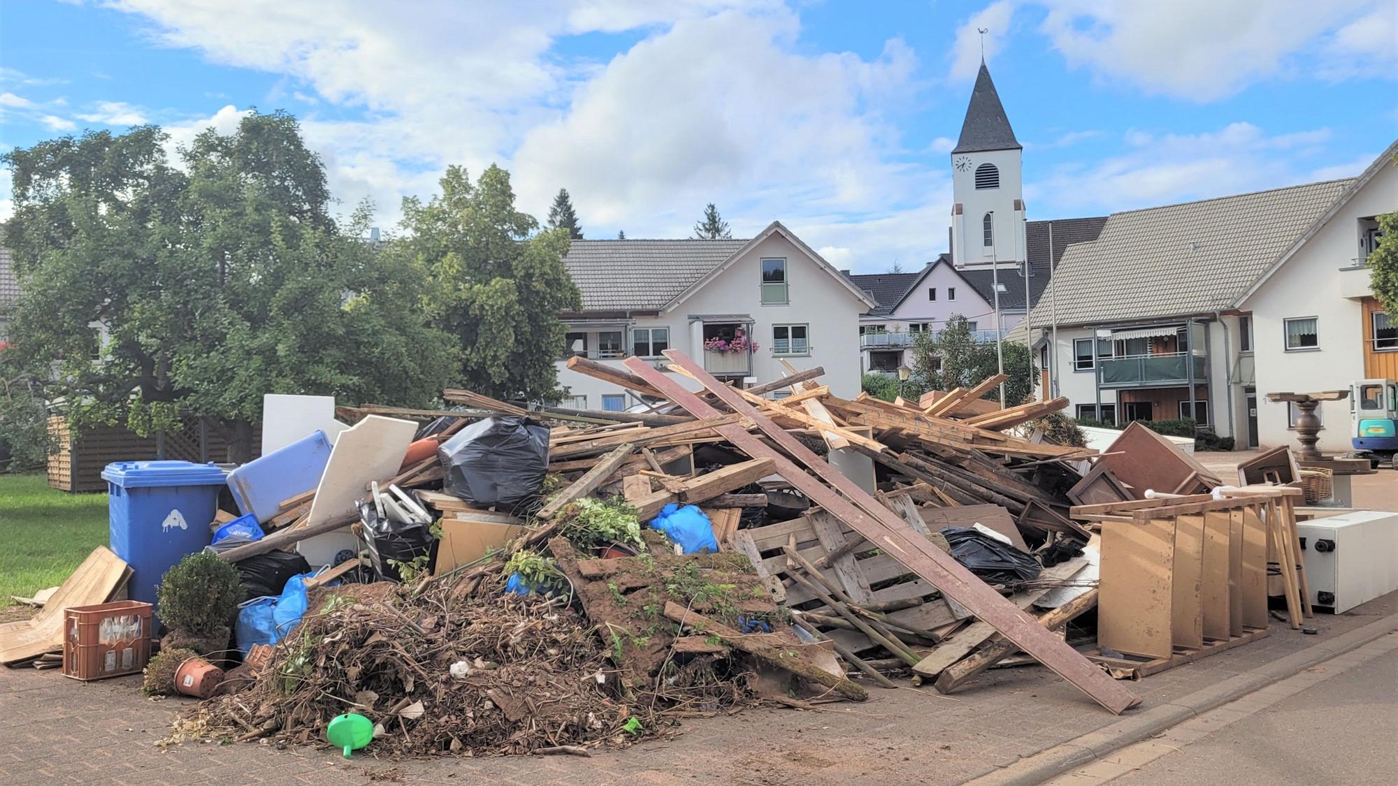 Ein Schuttberg liegt neben dem Markt in Kall. Im Hintergrund ist die Kirche zu sehen.