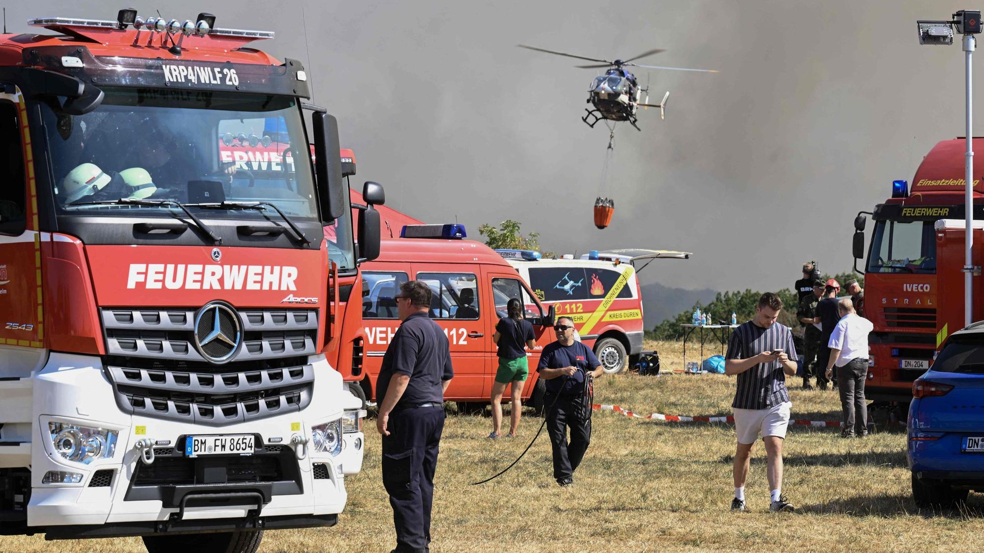 Ein Helikopter der Bundespolizei nimmt Wasser in Löschwasser-Außenlastbehältern zum Einsatz beim Waldbrand im Hürtgenwald auf. Mehrere Hundert Hektar Waldfläche stehen in Flammen.