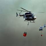 Helikopter fliegen an, um Wasser in Löschwasser-Außenlastbehältern zum Einsatz beim Waldbrand im Hürtgenwald aufzunehmen.