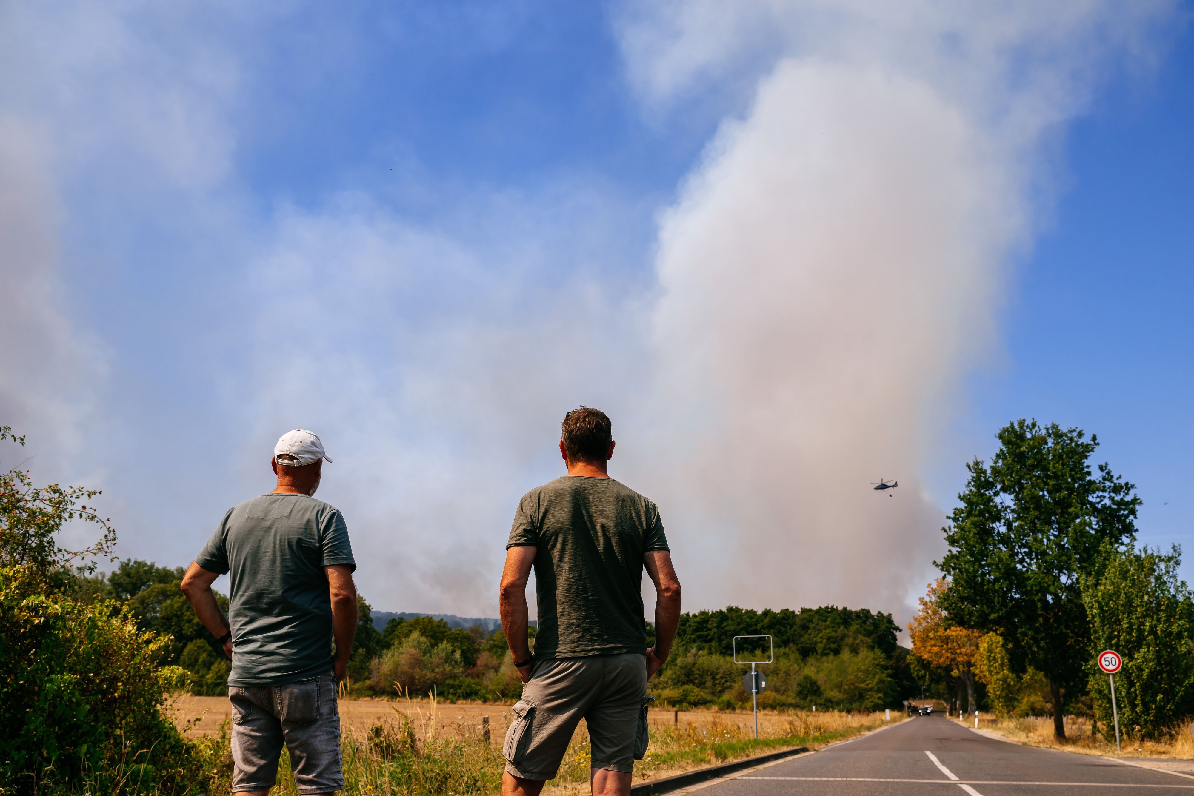Einwohner des Ortsteils Straß beobachten die Entwicklung des Brandes aus der Ferne.