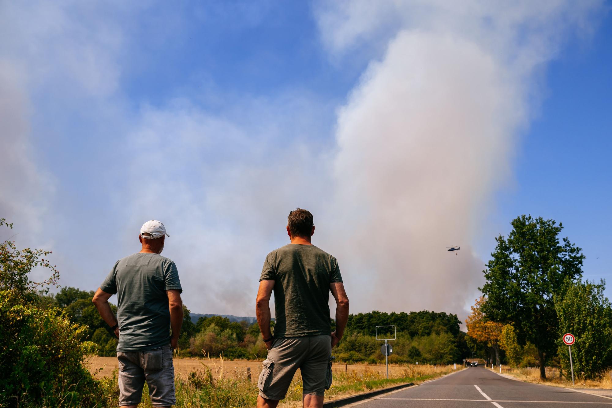 Einwohner des Ortsteils Straß beobachten die Entwicklung des Brandes aus der Ferne.
