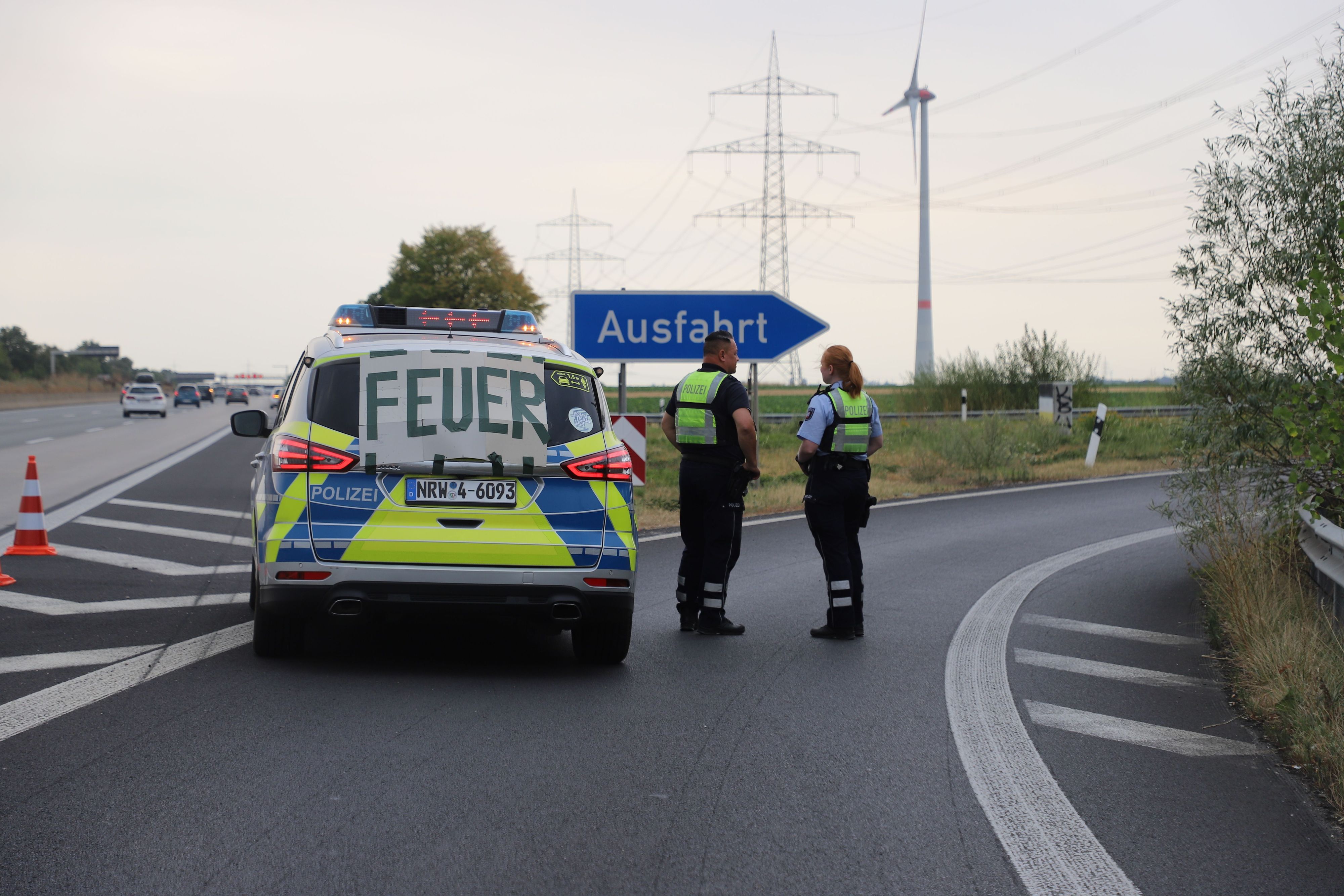Auf einem Banner an einem Fahrzeug der Polizei steht „Feuer“, während die Polizei die Autobahnabfahrt Langerwehe wegen des Waldbrands im Hürtgenwald gesperrt hat.