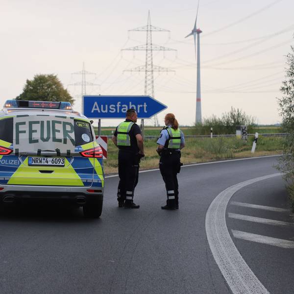 Auf einem Banner an einem Fahrzeug der Polizei steht „Feuer“, während die Polizei die Autobahnabfahrt Langerwehe wegen des Waldbrands im Hürtgenwald gesperrt hat.