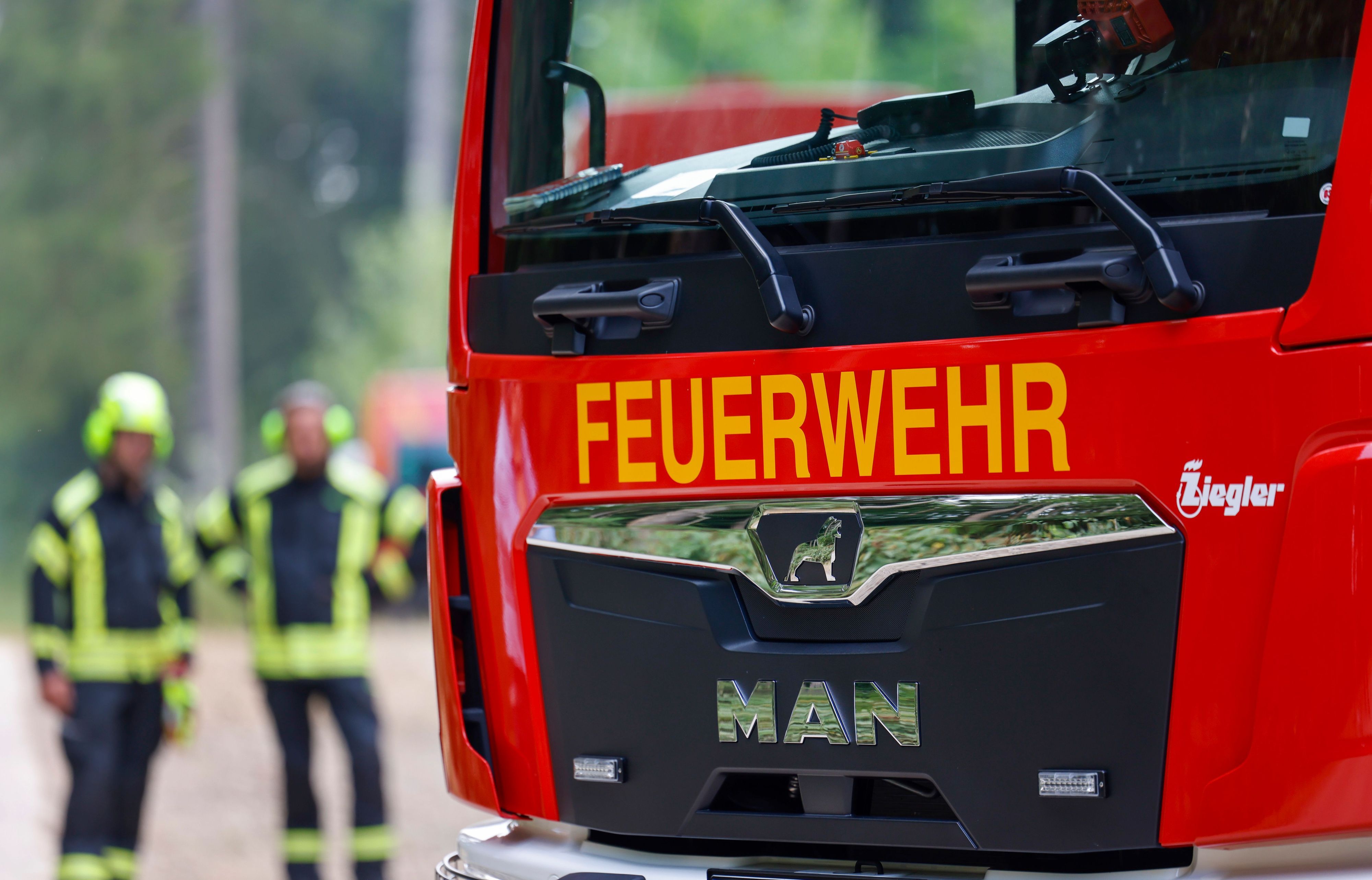 Ein Einsatzfahrzeug der Feuerwehr steht in einem Waldgebiet.
