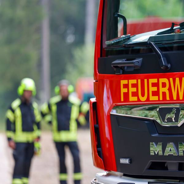 Ein Einsatzfahrzeug der Feuerwehr steht in einem Waldgebiet.