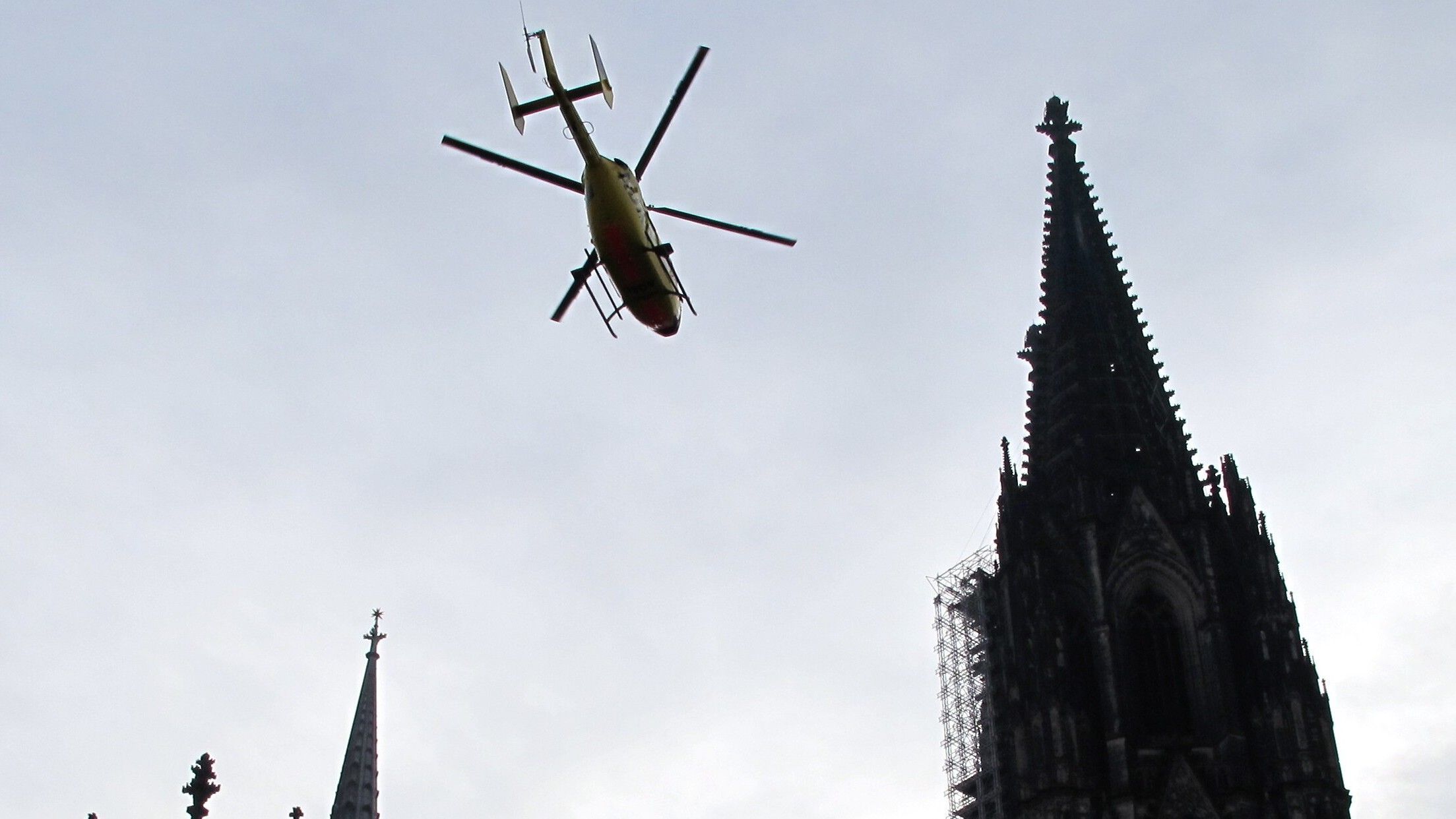 Ein ADAC-Rettungshubschrauber fliegt über den Dom in Köln hinweg. (Archivbild)