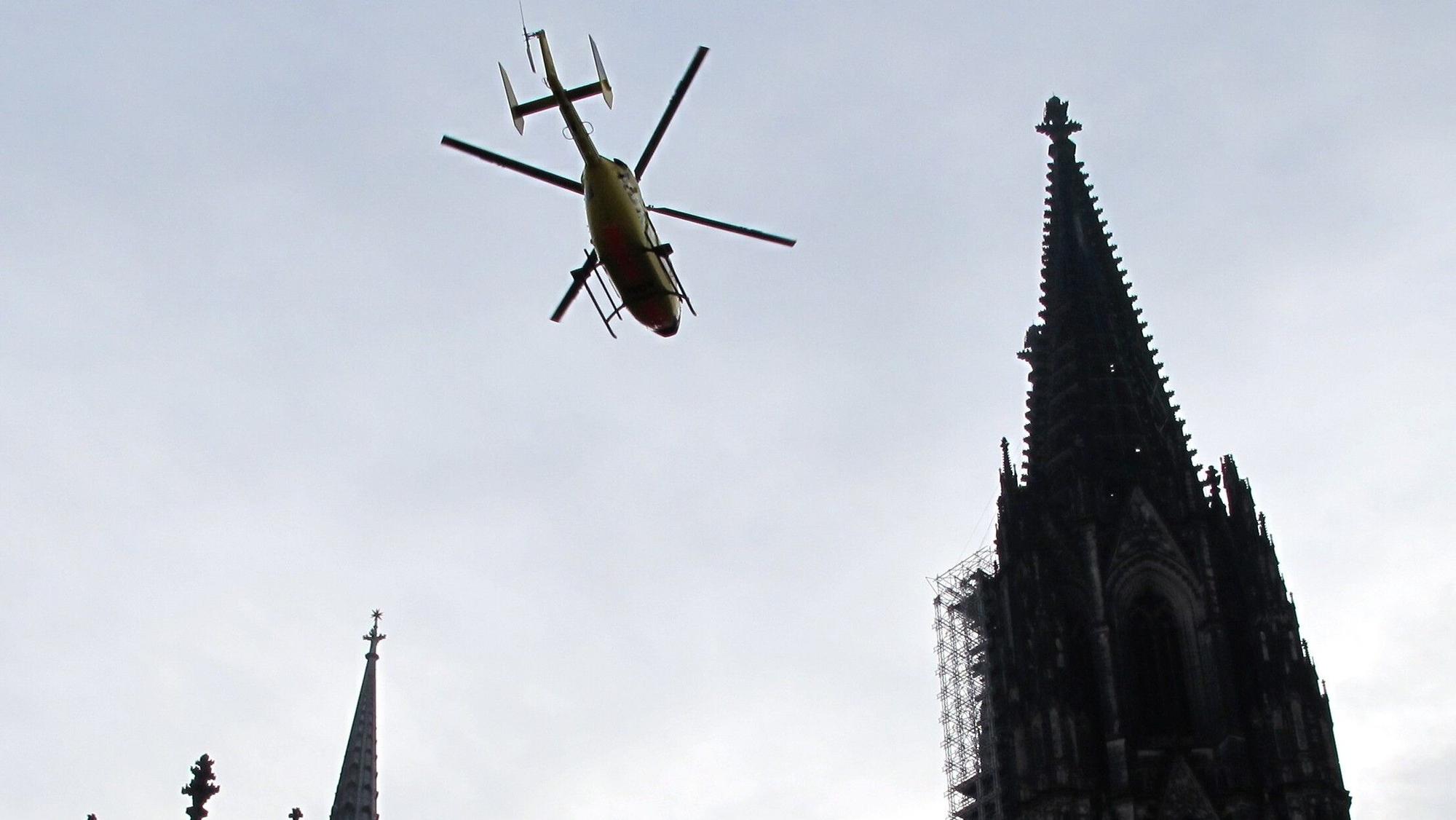 Ein ADAC-Rettungshubschrauber fliegt über den Dom in Köln hinweg. (Archivbild)
