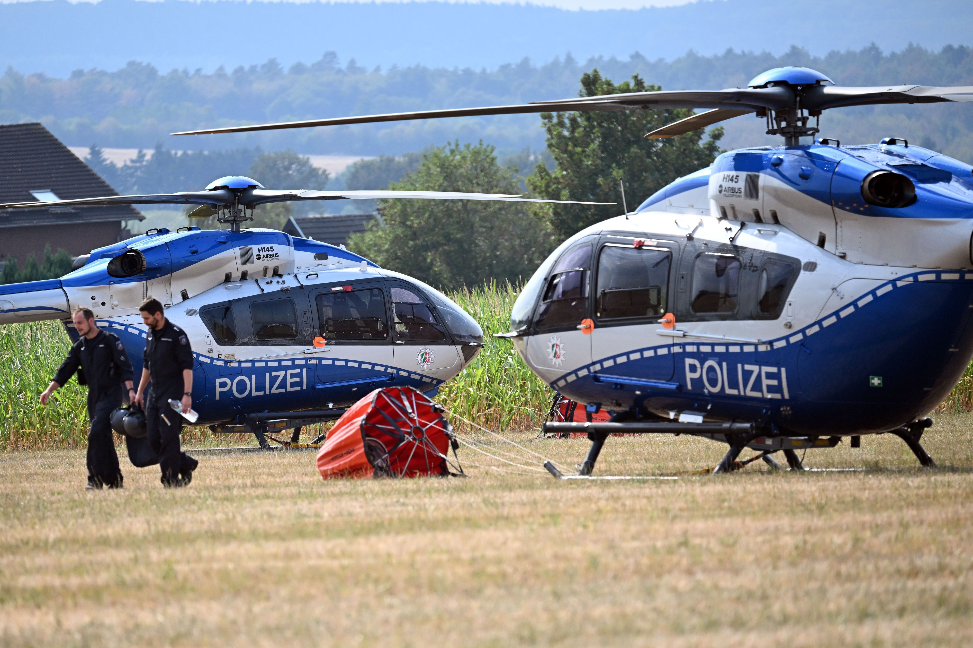 Hubschrauber der Polizei warten auf einem improvisierten Feldflugplatz auf den Einsatz.