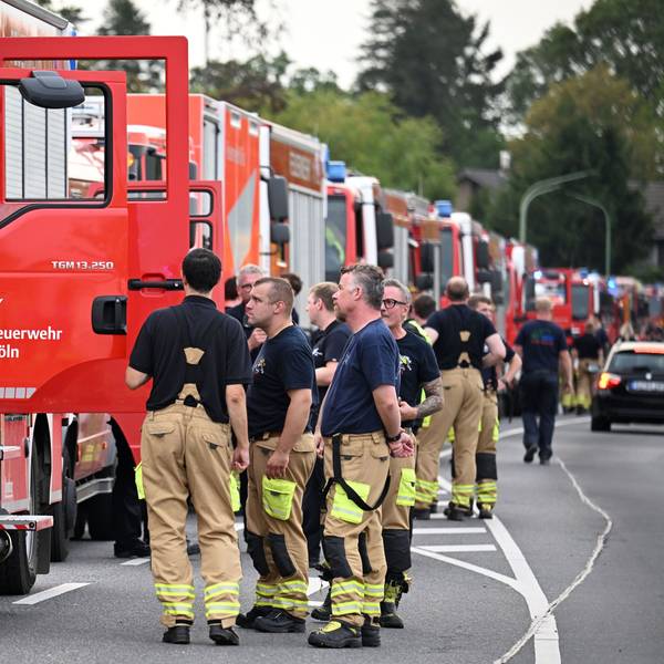 Zahlreiche Kräfte der Feuerwehr stehen an einer Straße. Sie sollen als Ablösung die Löscharbeit beim Waldbrand im Hürtgenwald übernehmen. Den Waldbrand haben die Einsatzkräfte unter Kontrolle gebracht.