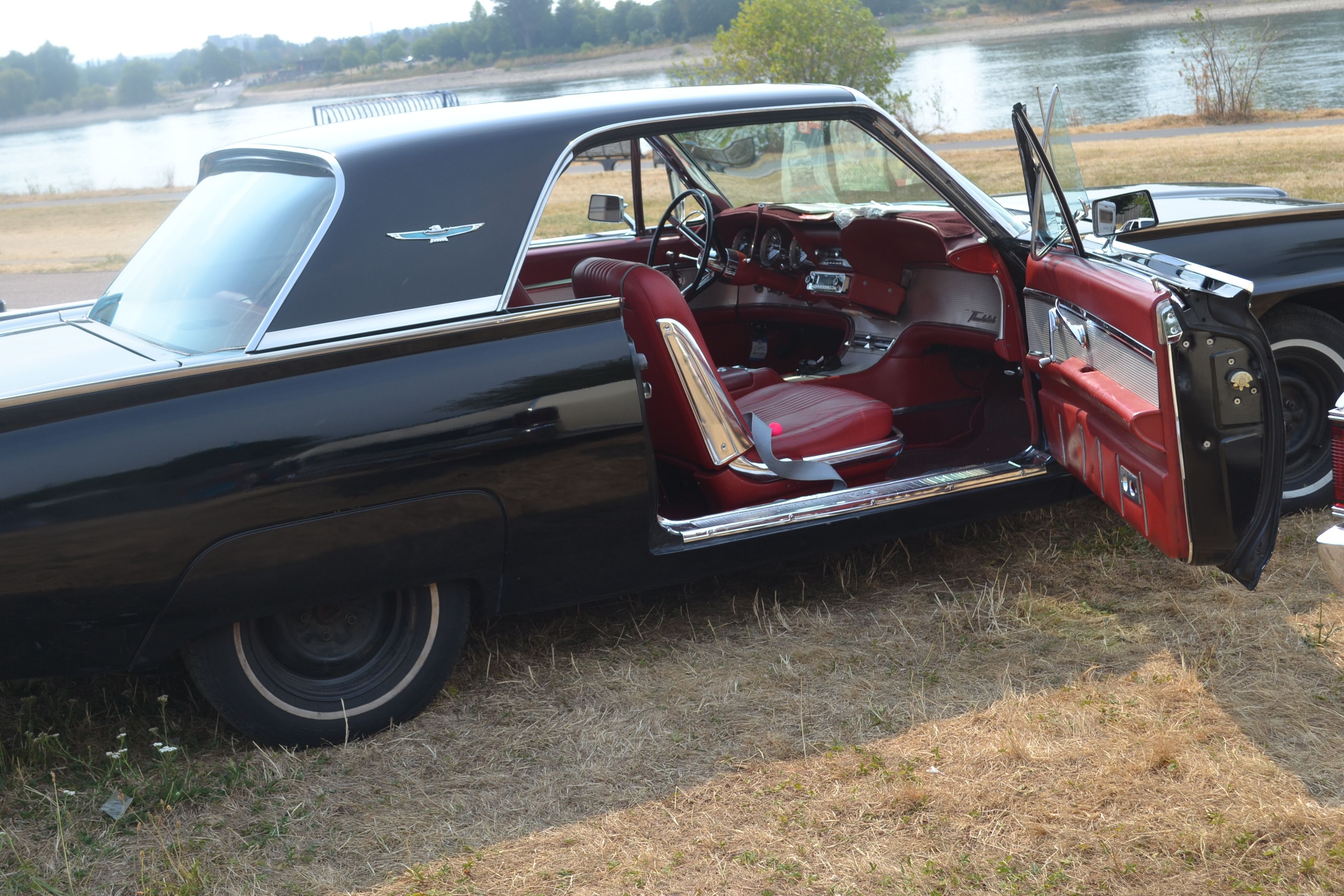Classic Cars Ausstellung in Niederkassel-Mondorf, schwarzer Oldtimer mit roten Sitzen und geöffneter Tür.