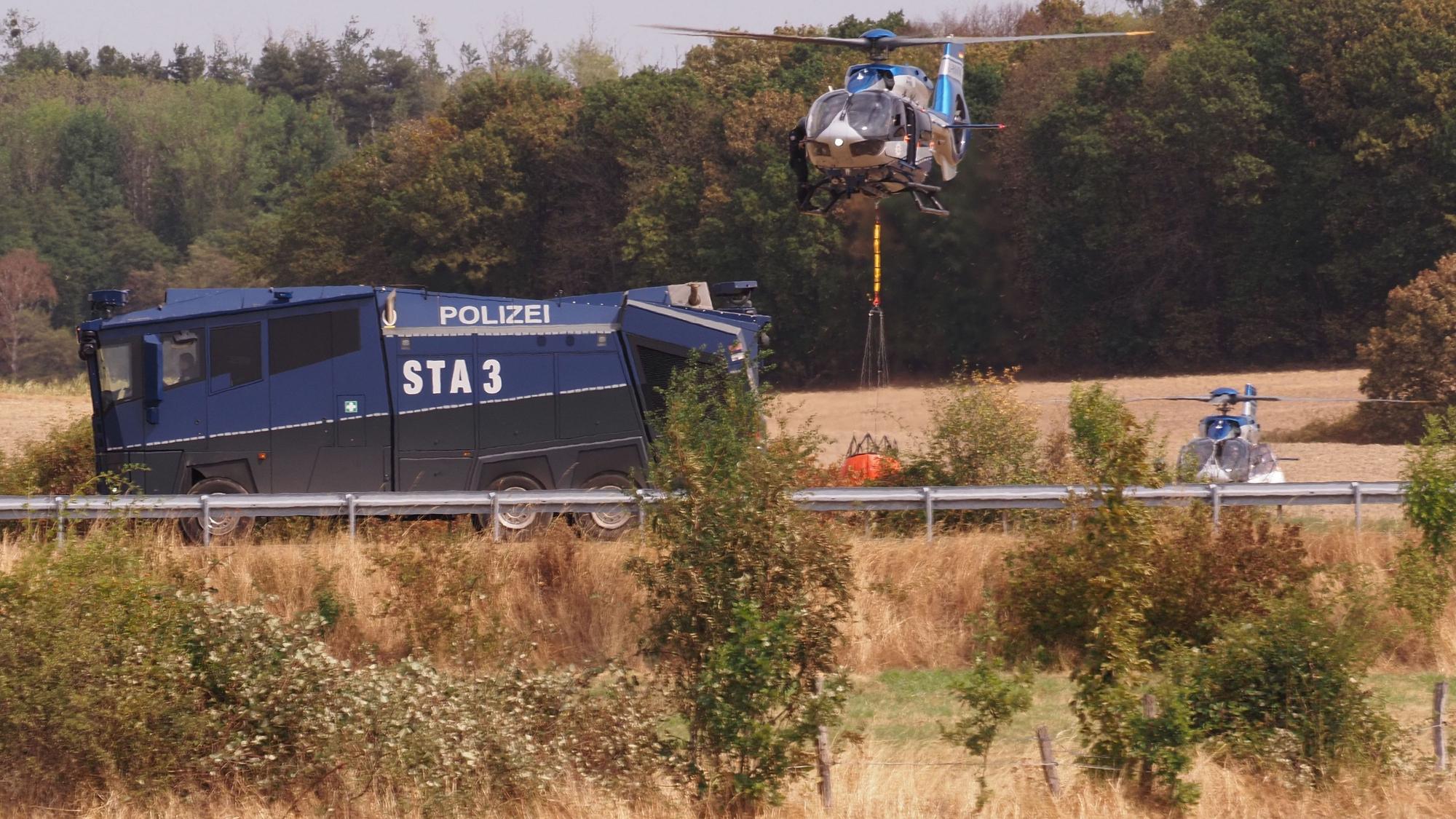 Löschhubschrauber und Wasserwerfer der Polizei nahe der Ortschaft Gey.