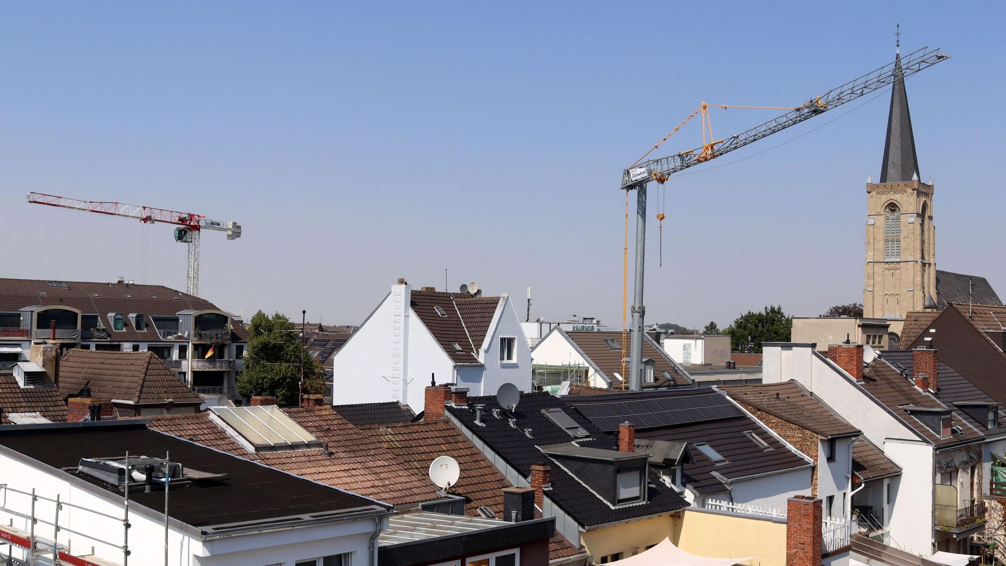 Über den Dächern der Stadt Euskirchen erheben sich zwei Baukräne, rechts ist die Herz-Jesu-Kirche zu sehen.