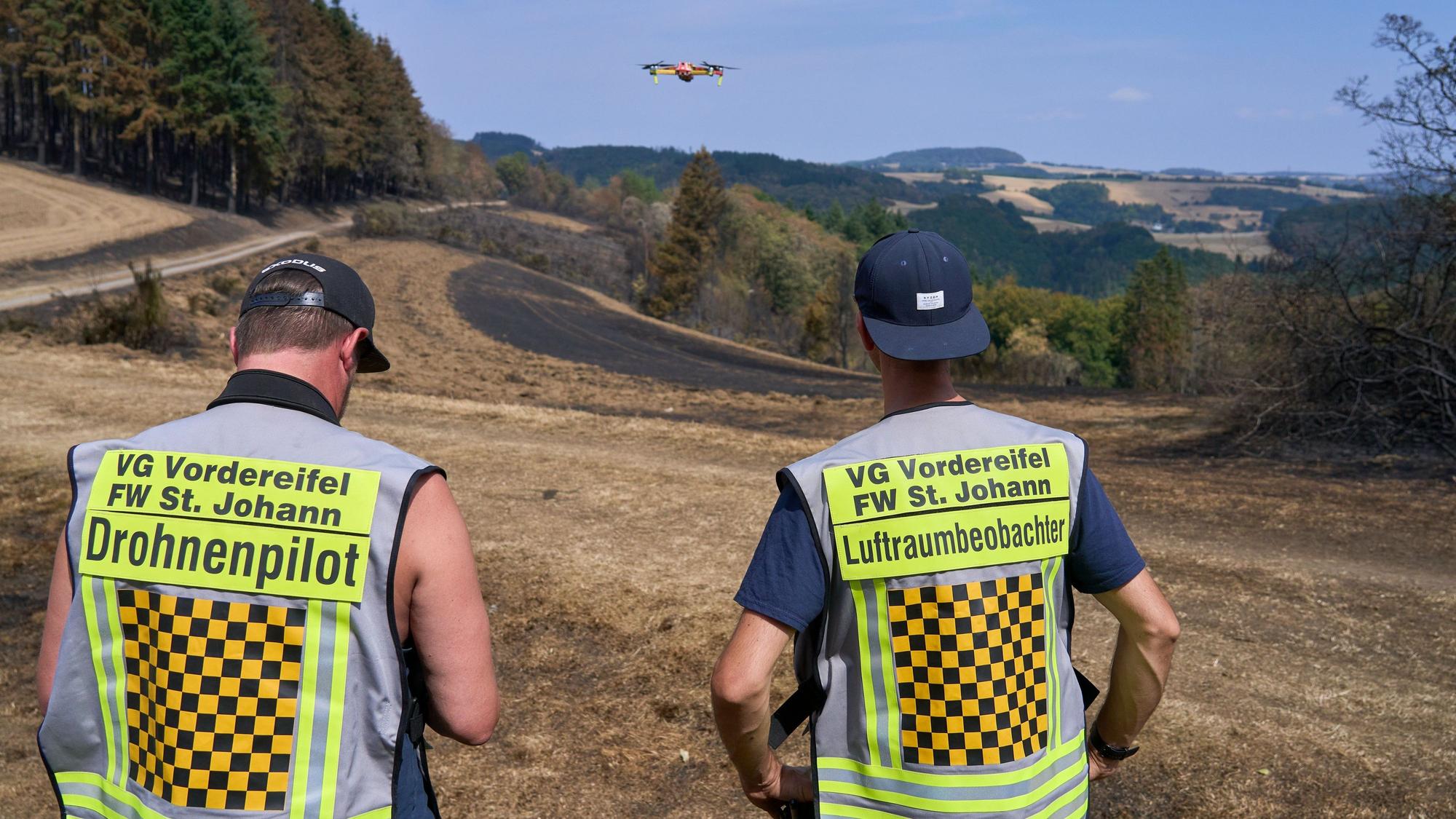 Langscheid in der Eifel: Mit der Wärmebildkamera suchen zwei Feuerwehrleute das Gelände nach Glutnestern ab.