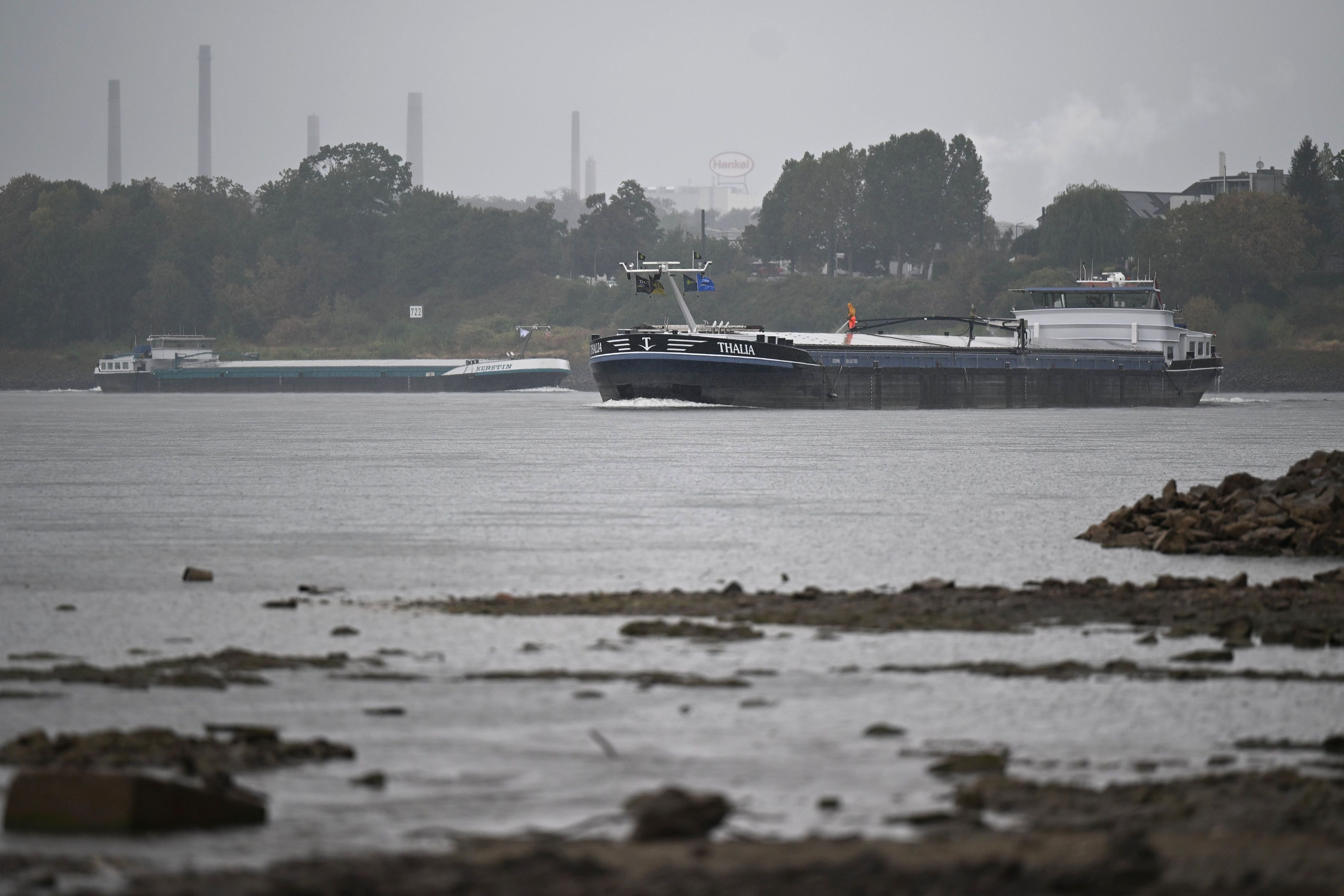 Zwei Frachtschiffe fahren in Düsseldorf auf dem Rhein. Es hat wieder ausgiebig geregnet. Der Pegelstand ist aber noch sehr niedrig, der Uferbereich viel breiter als zuvor.