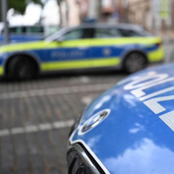 Polizeifahrzeuge stehen vor einer Polizeiwache.