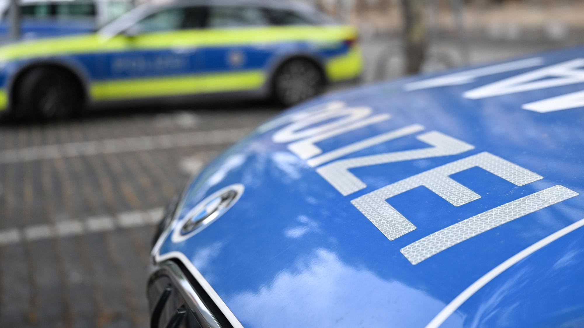 Polizeifahrzeuge stehen vor einer Polizeiwache.