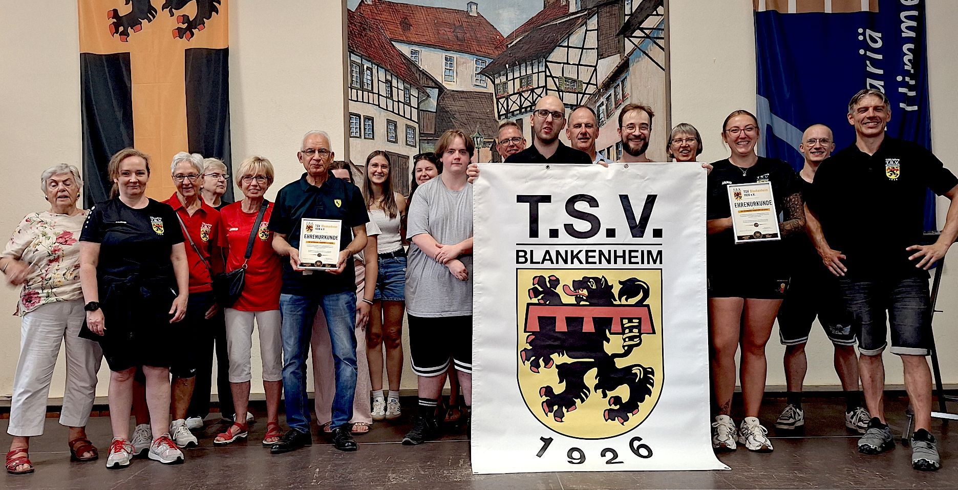 Einige Mitglieder haben sich zum Gruppenfoto postiert und halten des Vereins banner.