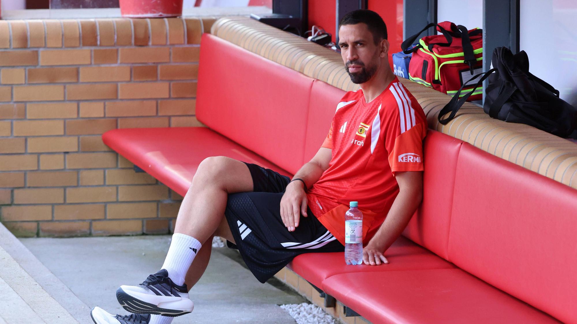 Rani Khedira sitzt entspannt auf der Bank.