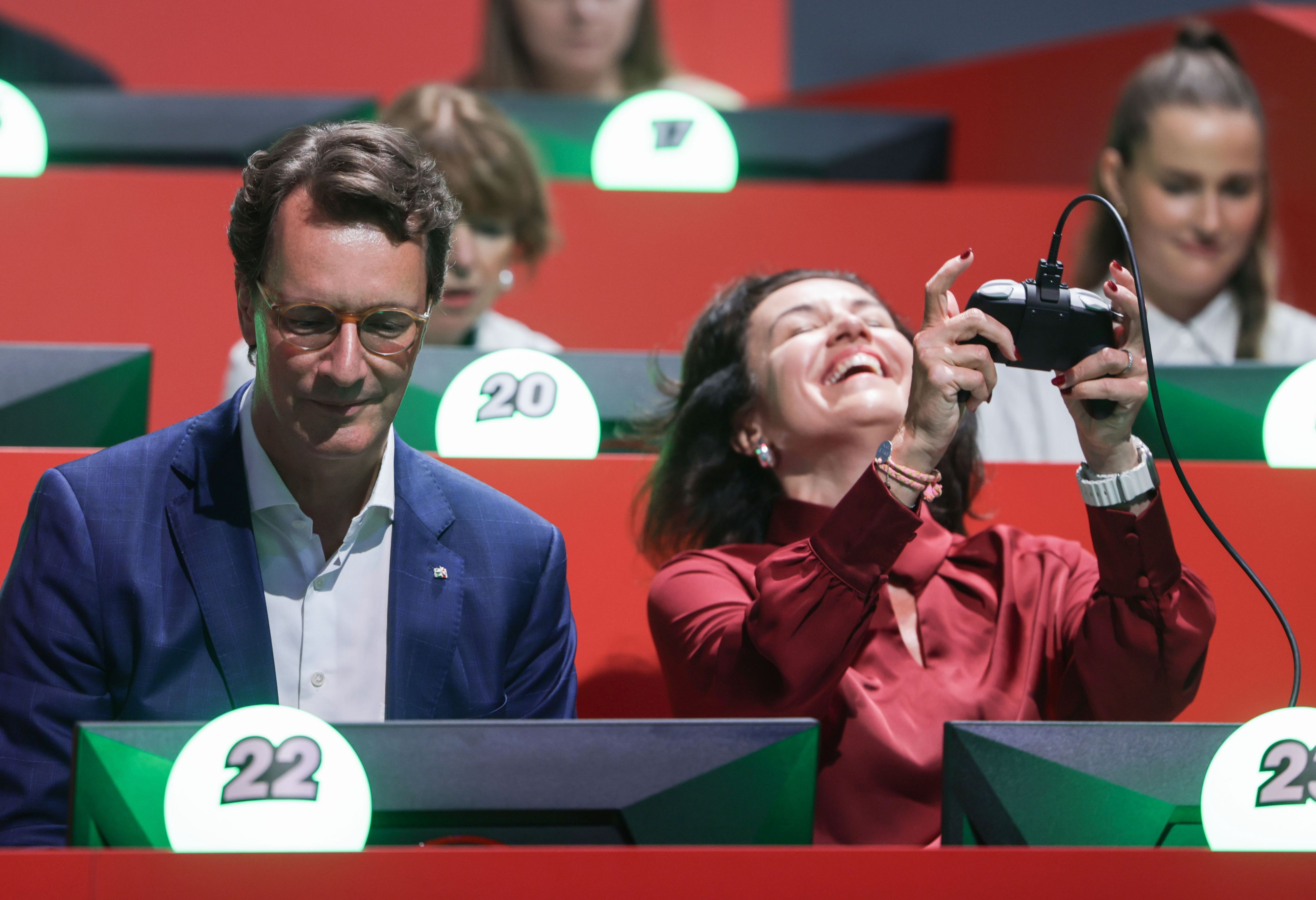 Hendrik Wüst und Dorothee Bär spielen beim Eröffnungsrundgang am Stand von Nintendo Super Mario.