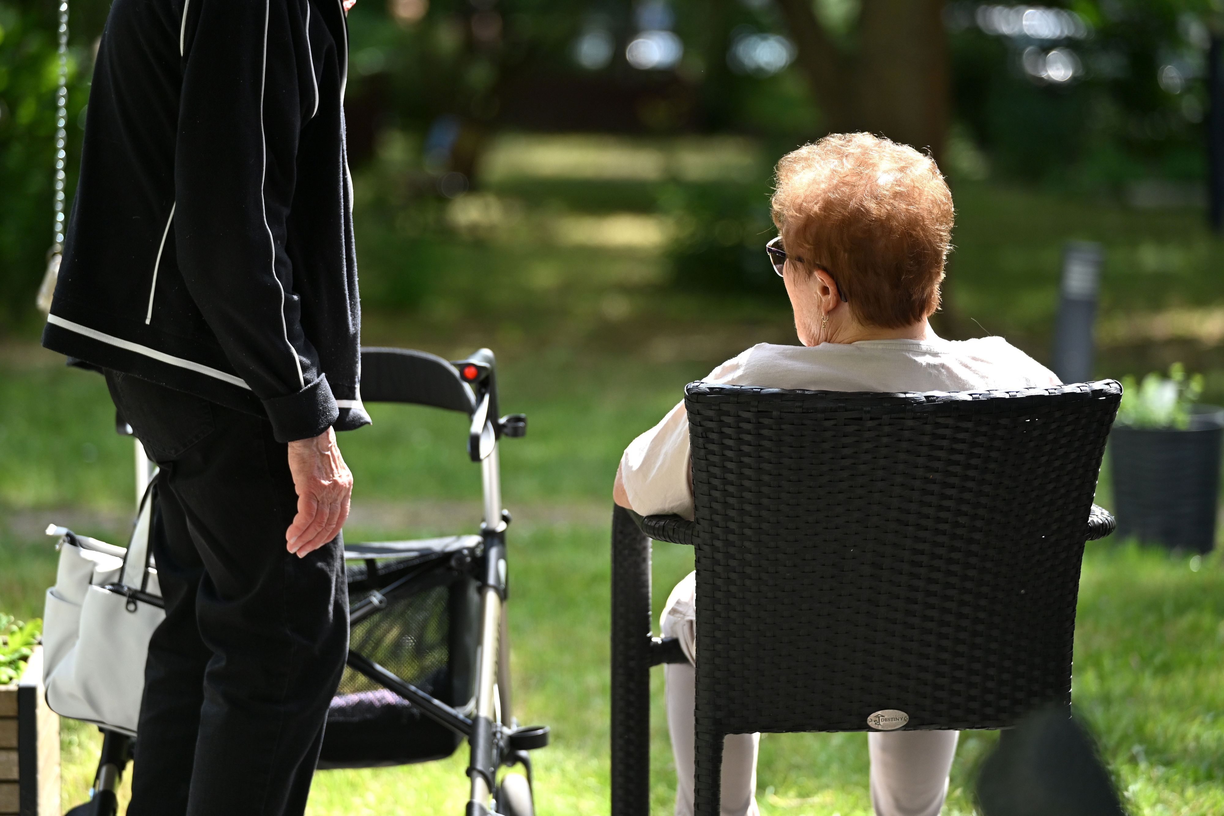 Zwei Senioren sprechen in dem Garten eines Pflegeheims miteinander. Hitze stellt insbesondere für ältere und pflegebedürftige Menschen ein Risiko dar. (Archivbild)