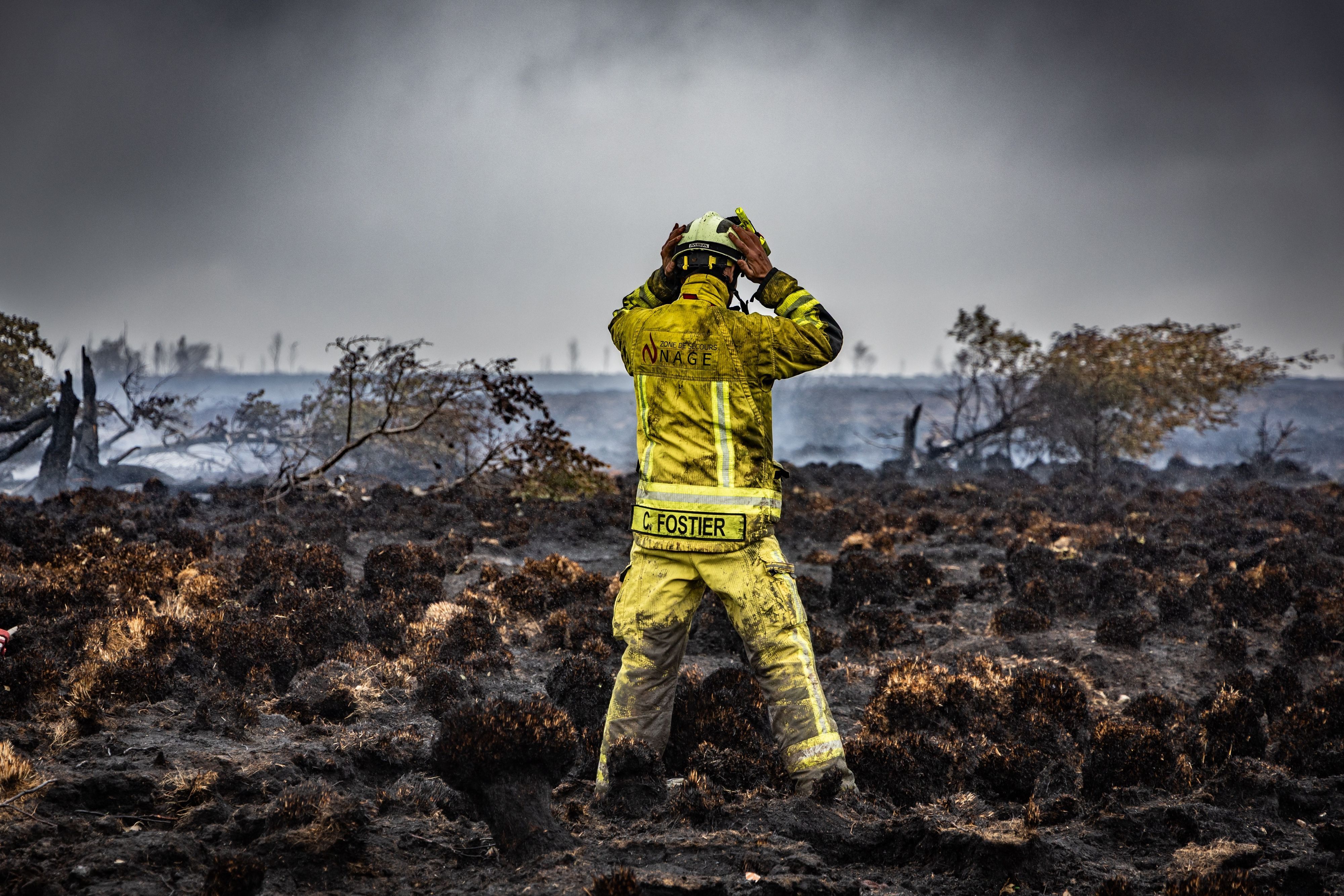 Ein Feuerwehrmann steht am Brandort im Naturschutzgebiet Hohes Venn.