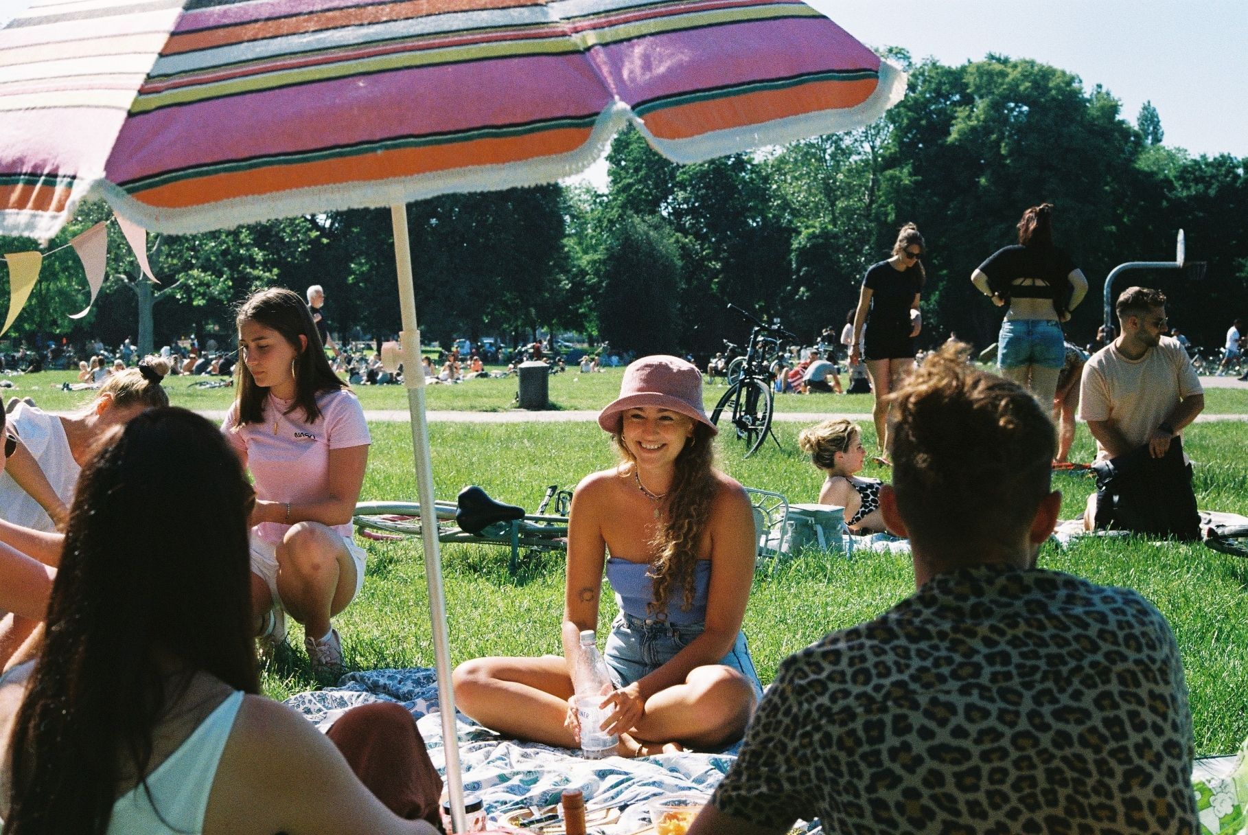 Eine Frau sitzt lachend auf einer Picknick-Decke.