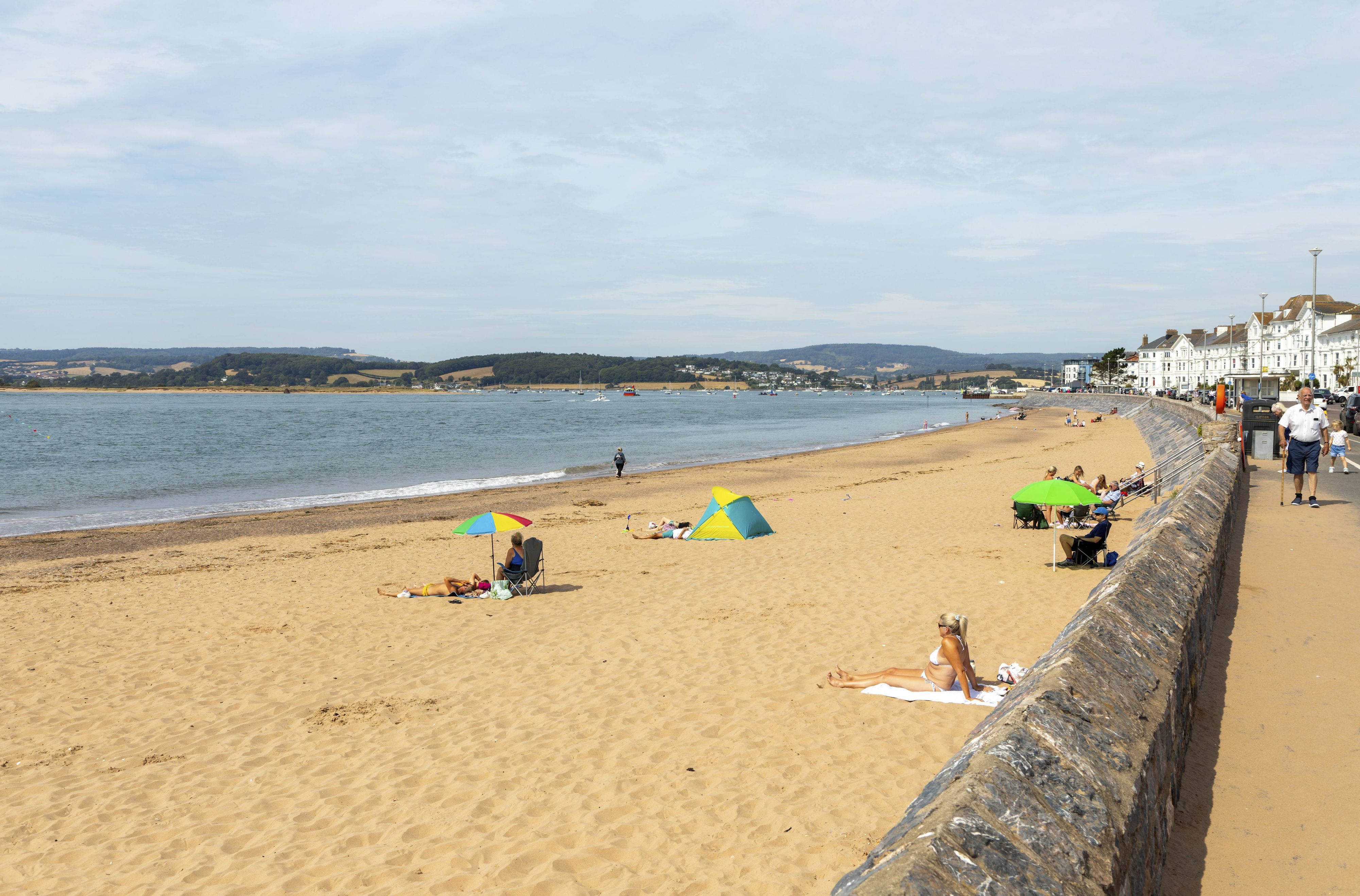 Menschen am Sandstrand und an der Strandpromenade der Küstenstadt Exmouth im englischen Devon.