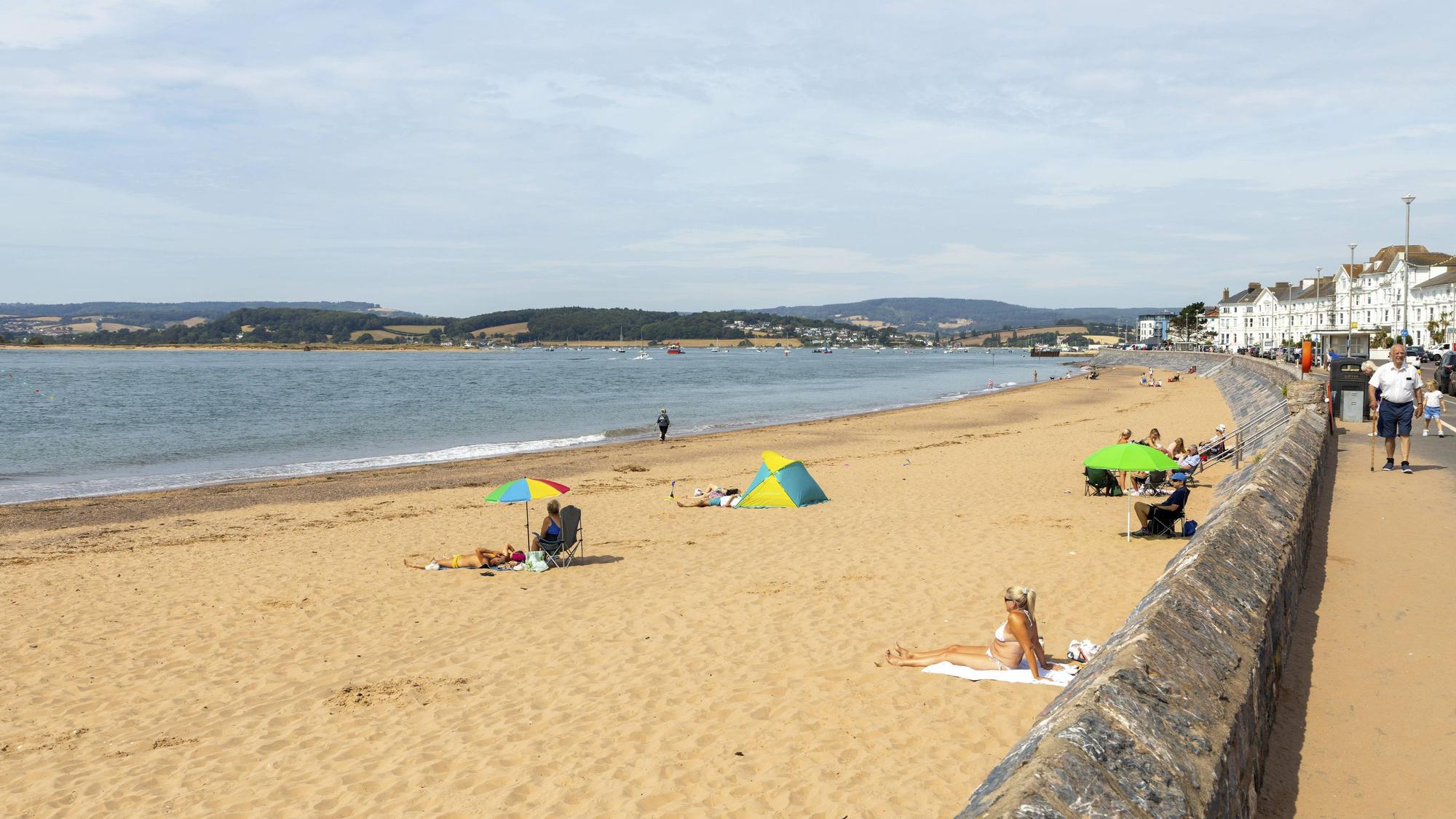 Menschen am Sandstrand und an der Strandpromenade der Küstenstadt Exmouth im englischen Devon.