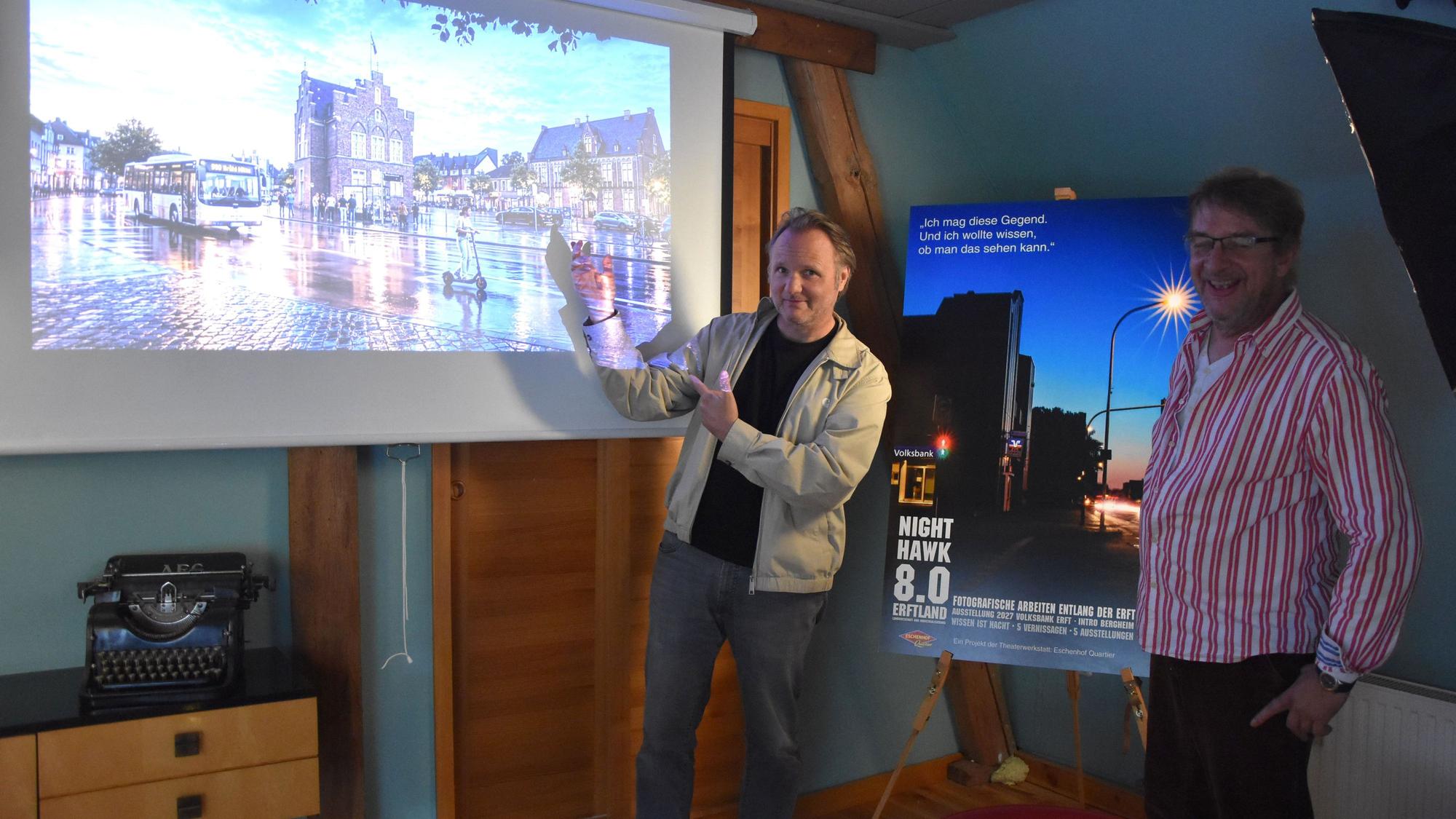 Das Foto zeigt zwei Männer vor einer Projektion eines Beamers.