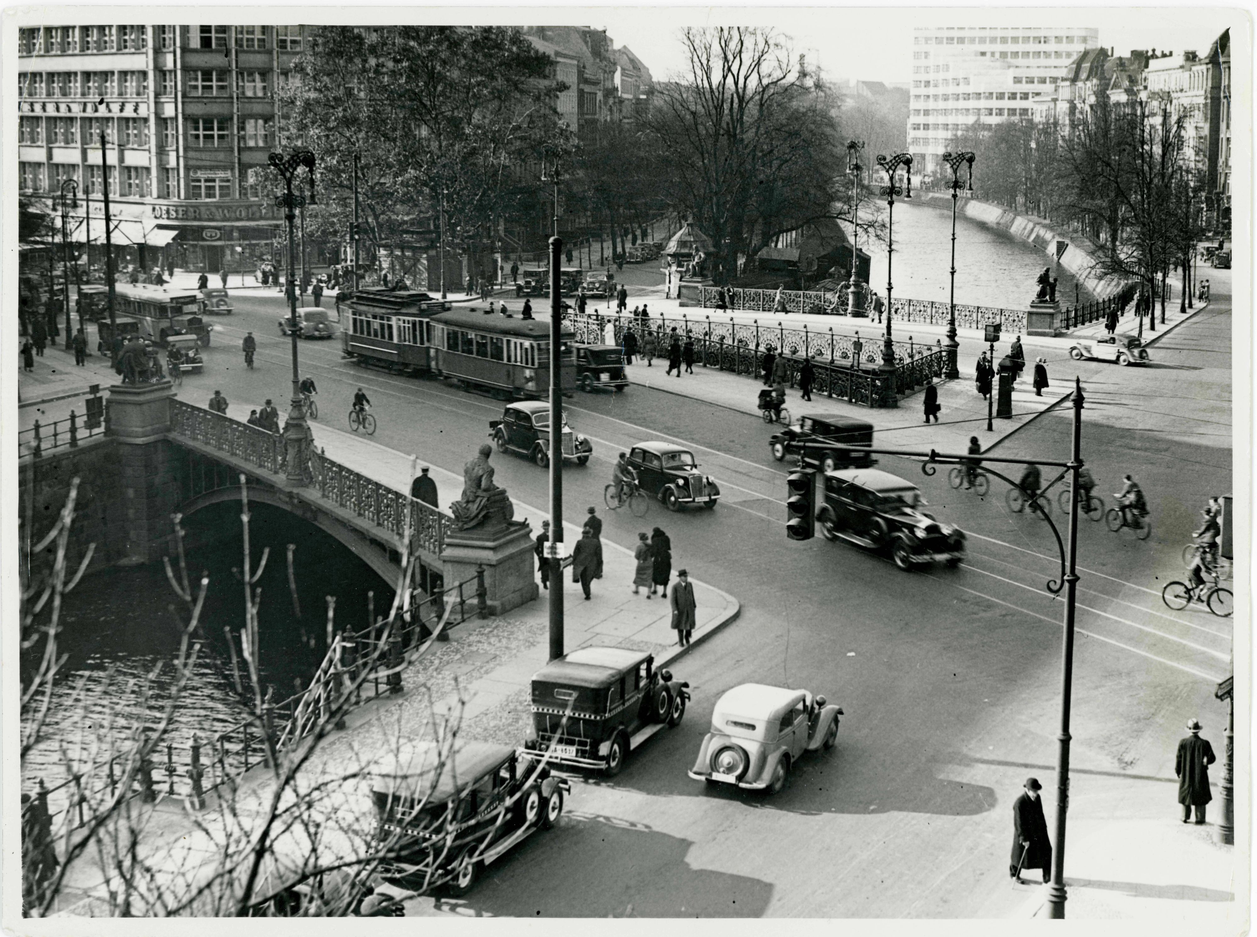 Ein Foto, das 1935 aufgenommen wurde, zeigt eine Straßenkreuzung mit einer Brücke, die über einen Kanal führt.
