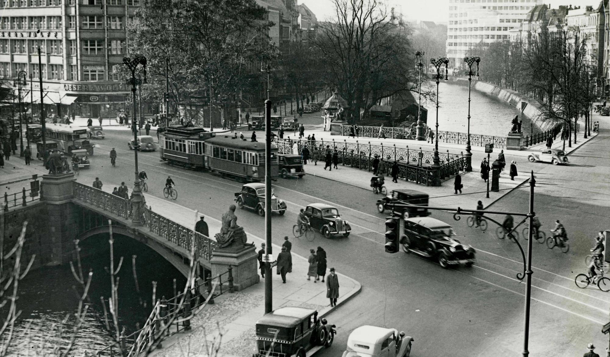 Ein Foto, das 1935 aufgenommen wurde, zeigt eine Straßenkreuzung mit einer Brücke, die über einen Kanal führt.