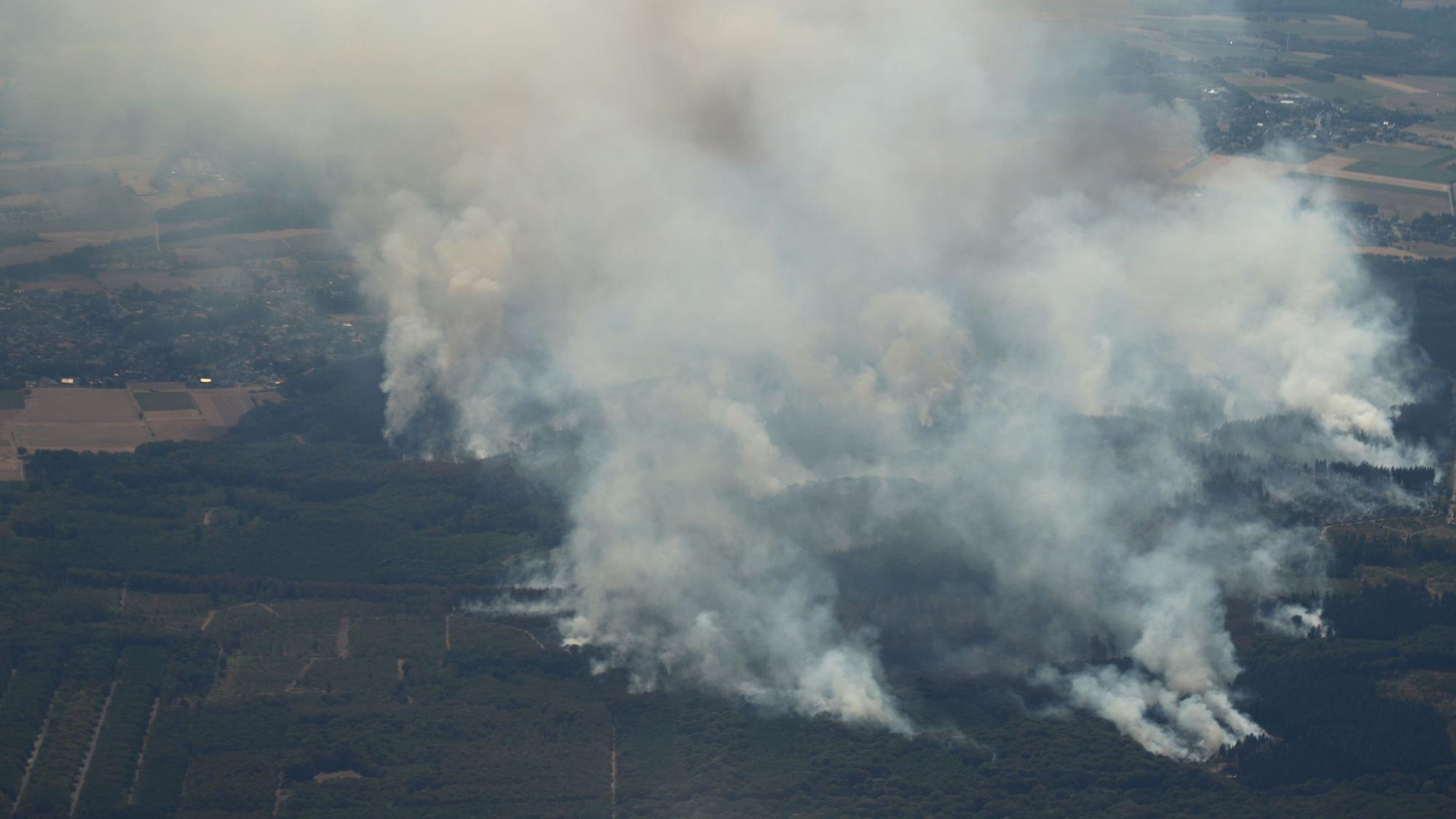 14.08.2026, Nordrhein-Westfalen, Düren: Rauch eines Waldbrands steigt über dem Hürtgenwald auf (Aufnahme aus einem Flugzeug). Mehrere Hundert Hektar Waldfläche stehen in Flammen. Foto: Sascha Thelen/dpa +++ dpa-Bildfunk +++