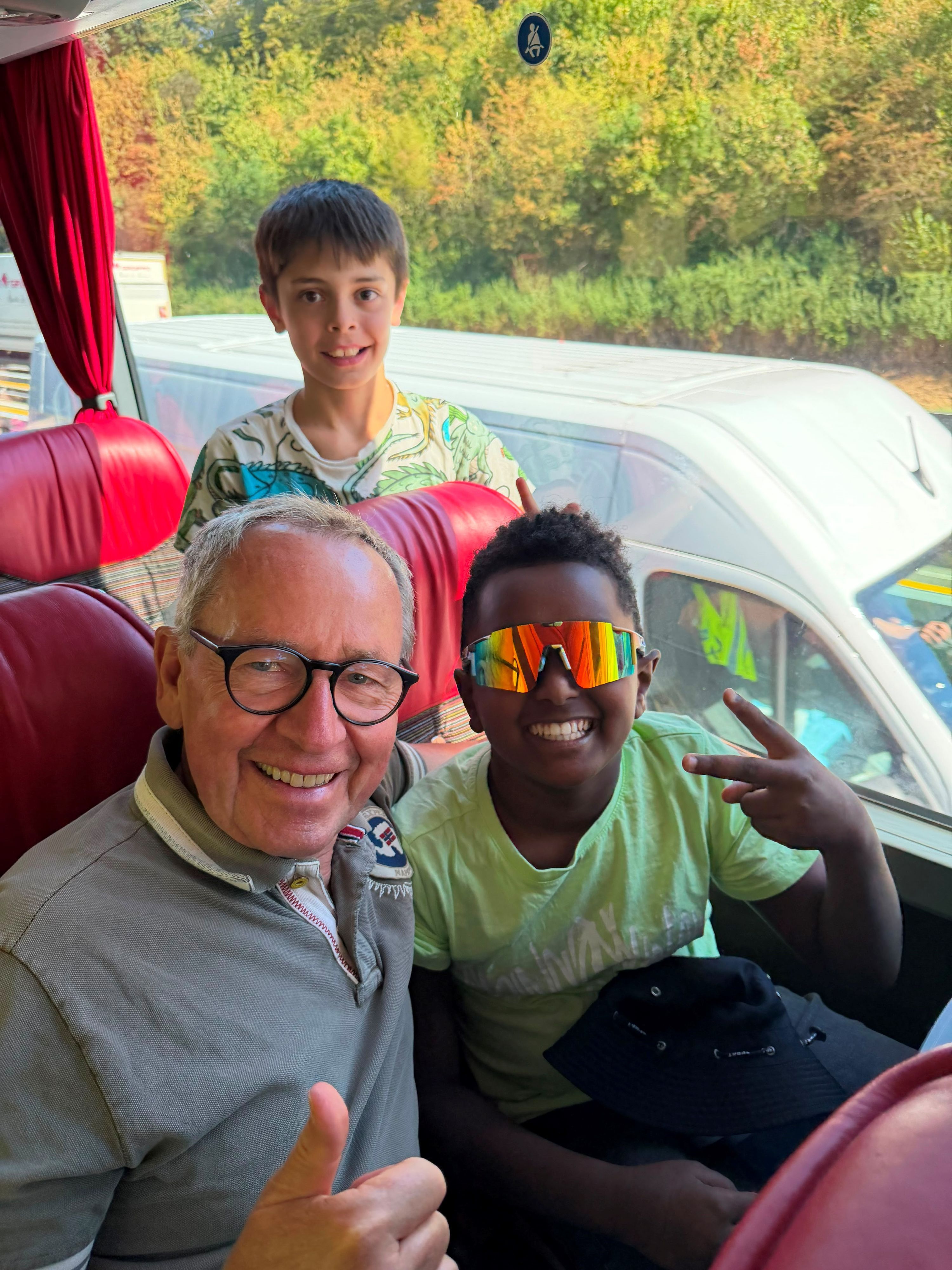 Ferdinand Linzenich sitzt mit einem Kind im Bus.