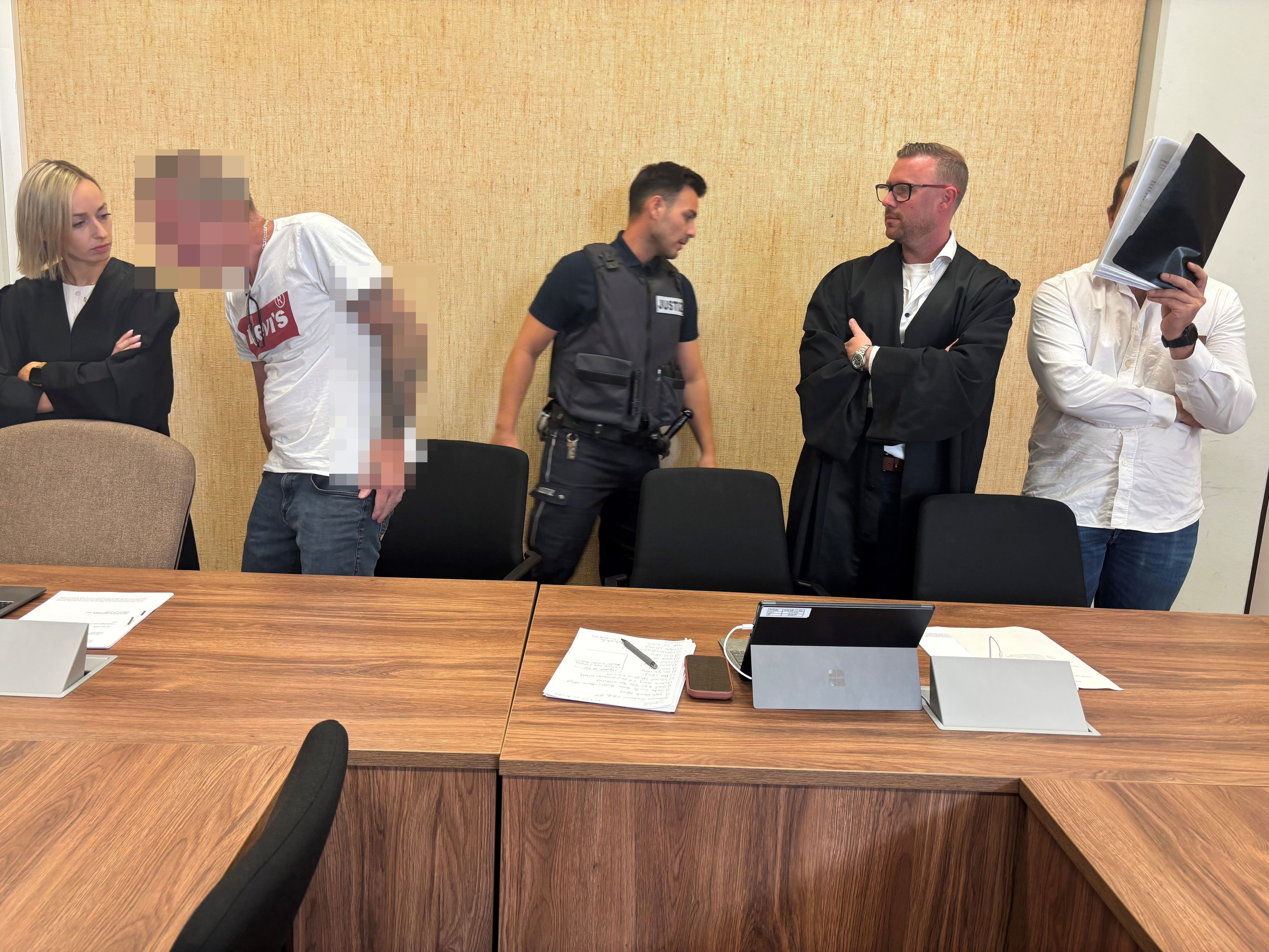 Angeklagte und Verteidiger stehen vor dem Kölner Landgericht.